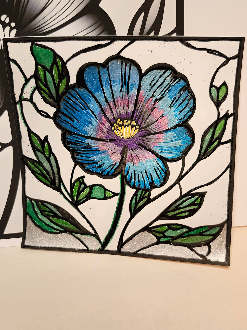 Stained glass panel with a blue flower design on a beige background
