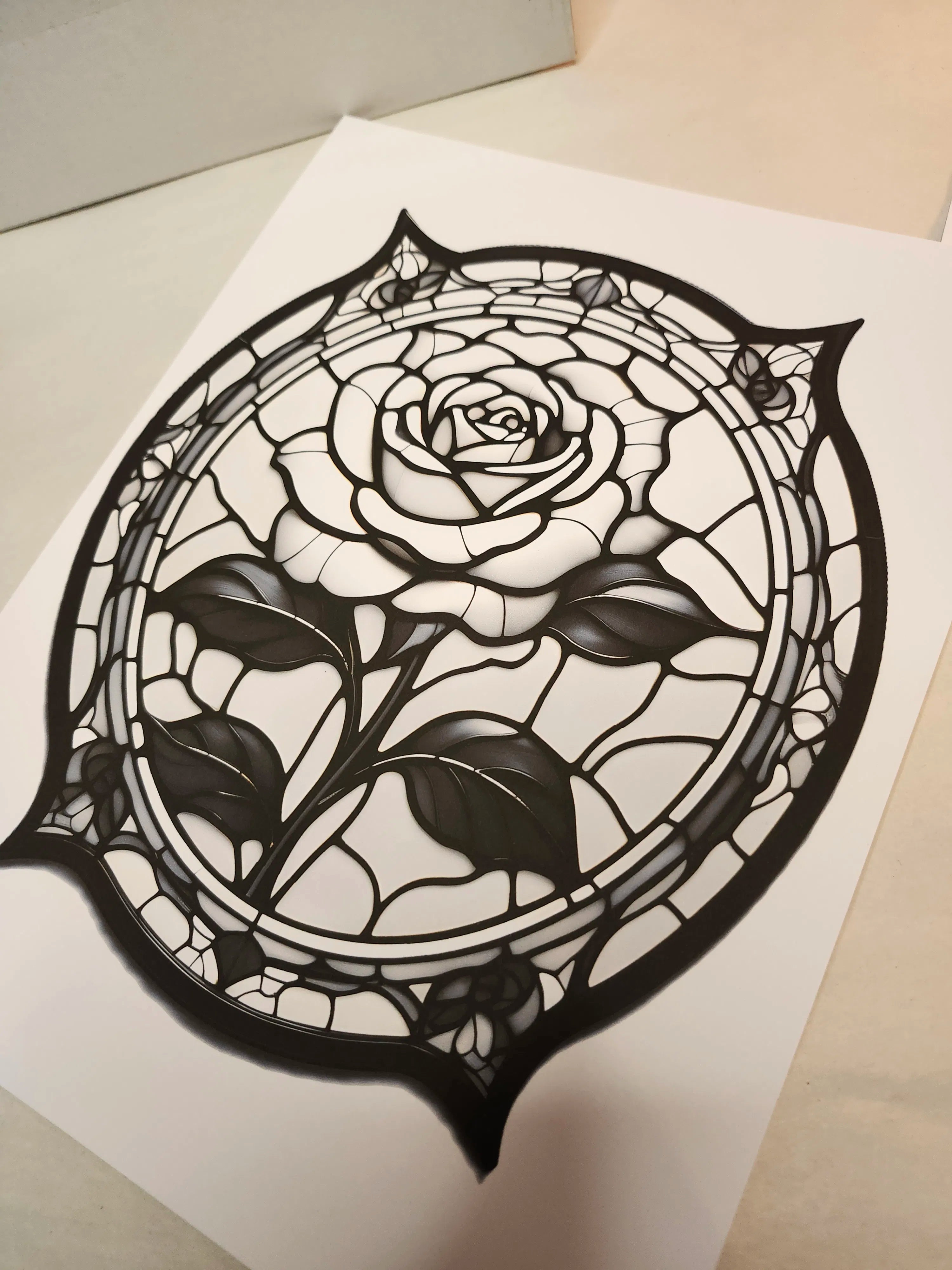 Decorative paper cutout of a rose with a black border on a white background