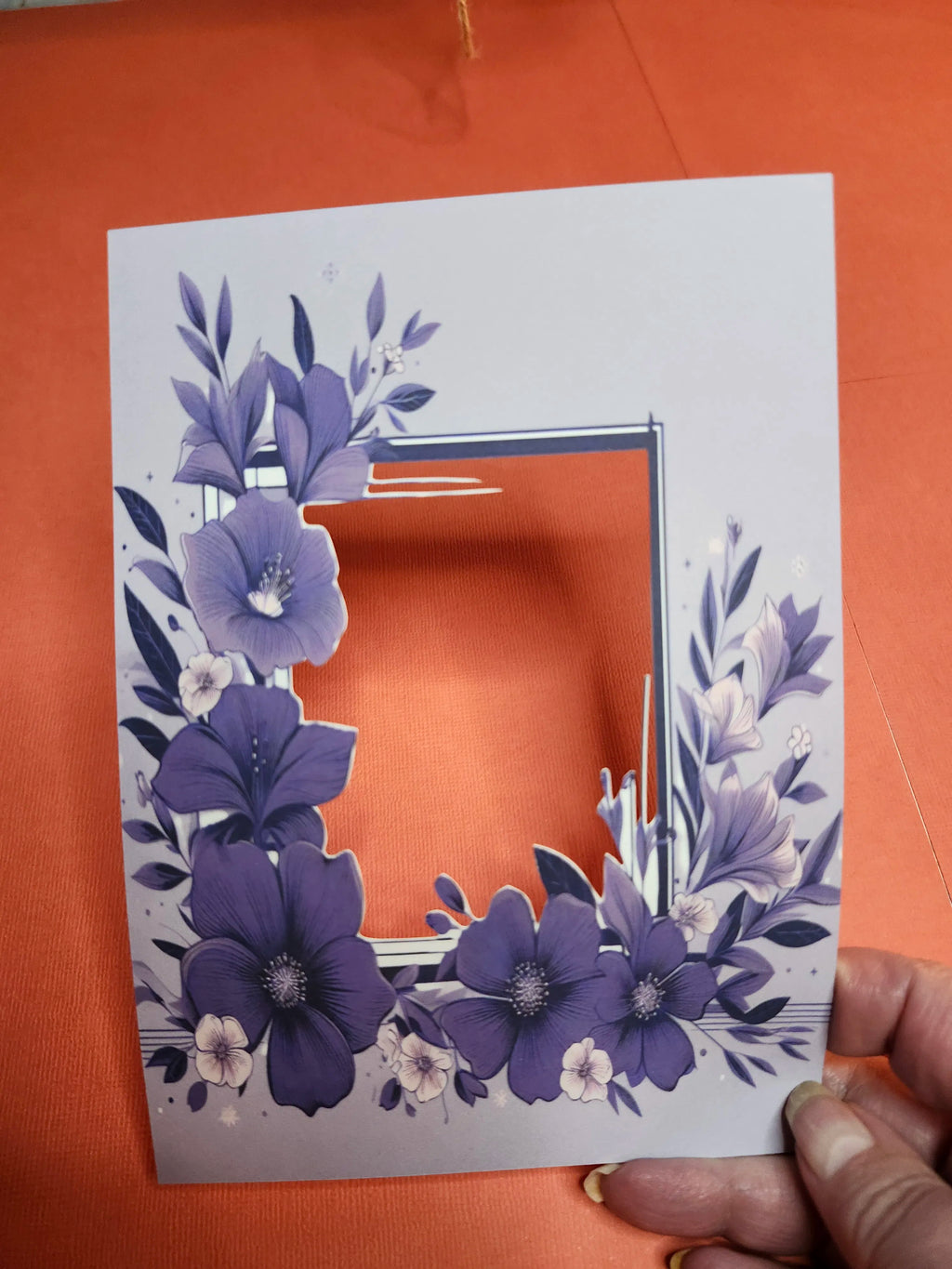 Card with 3D purple floral design on an orange background