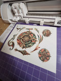Cricut machine with decorative paper featuring intricate designs on a purple grid background