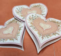 Heart-shaped cards with floral designs on an orange background