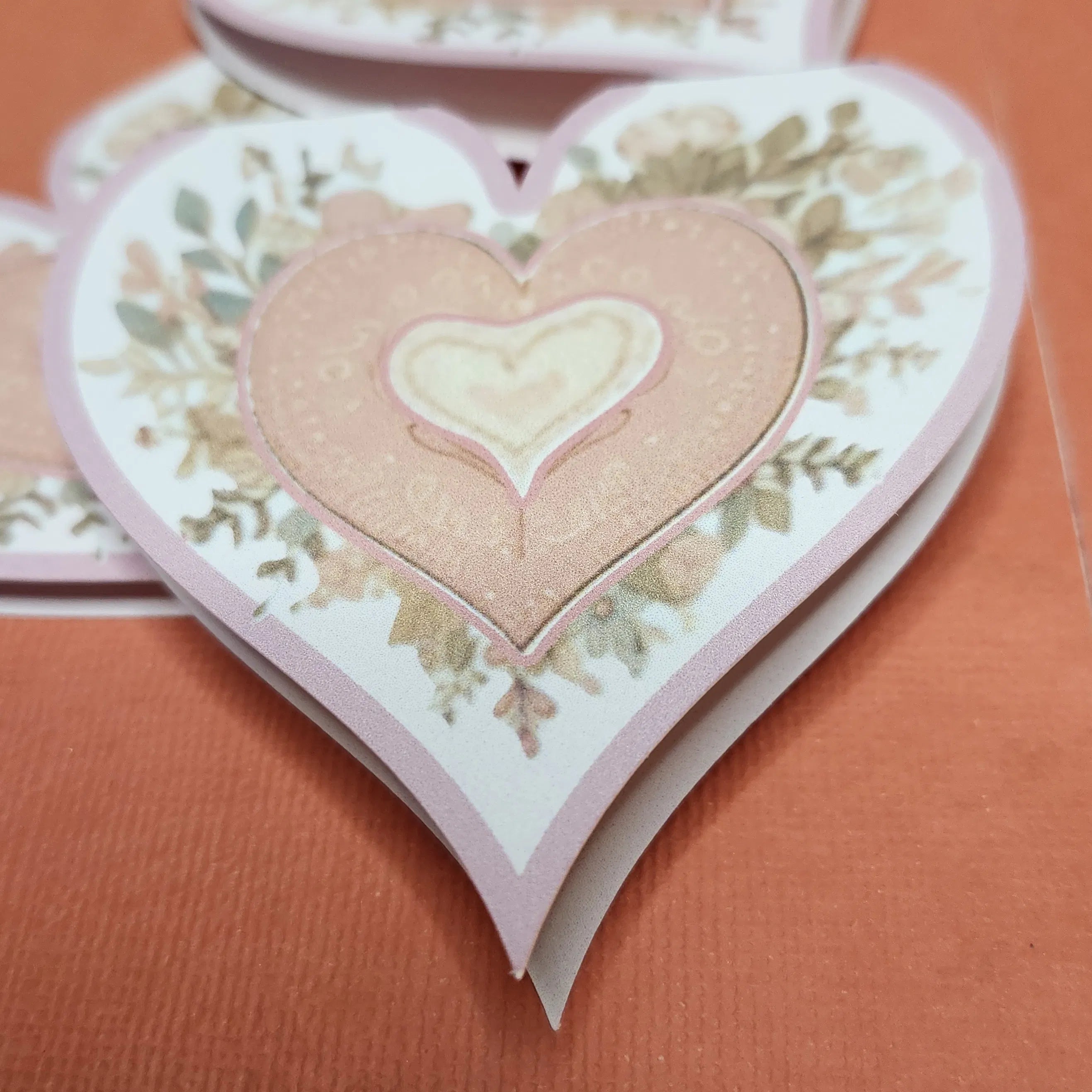 Heart-shaped card with floral design on a brown background