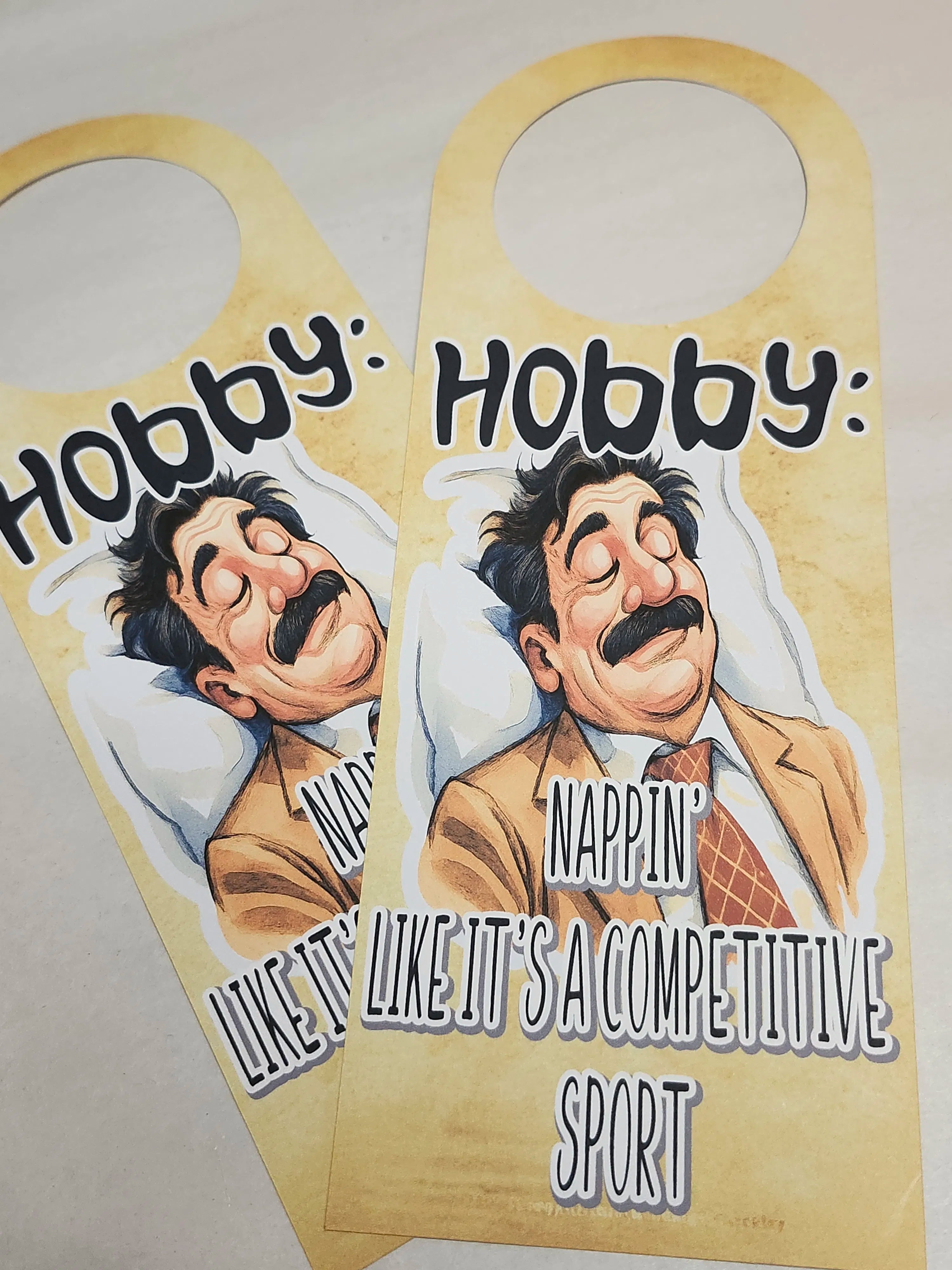 Two door hangers with a cartoon character and humorous text on a beige background.