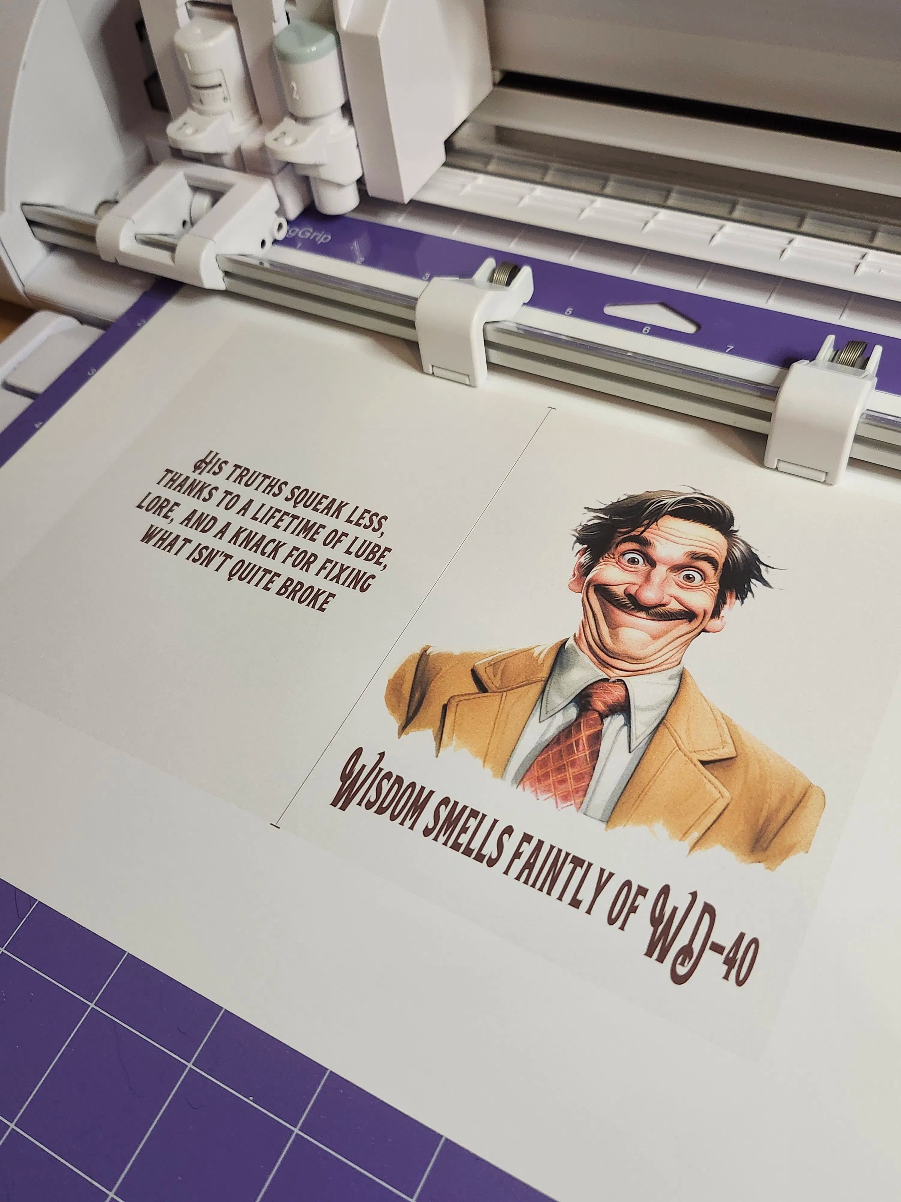 Cricut machine with a printed design of a man with a mustache and text on a cutting mat.