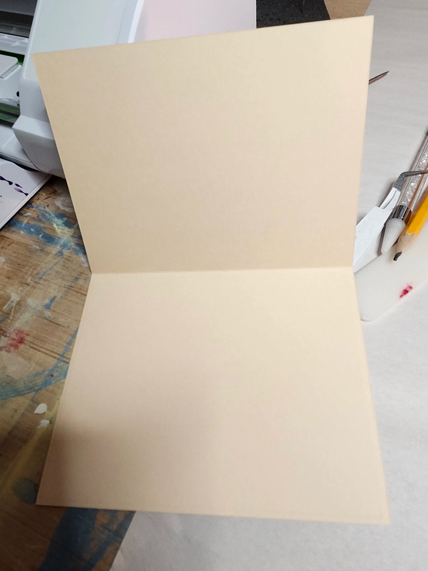 Beige paper on a desk with office supplies in the background