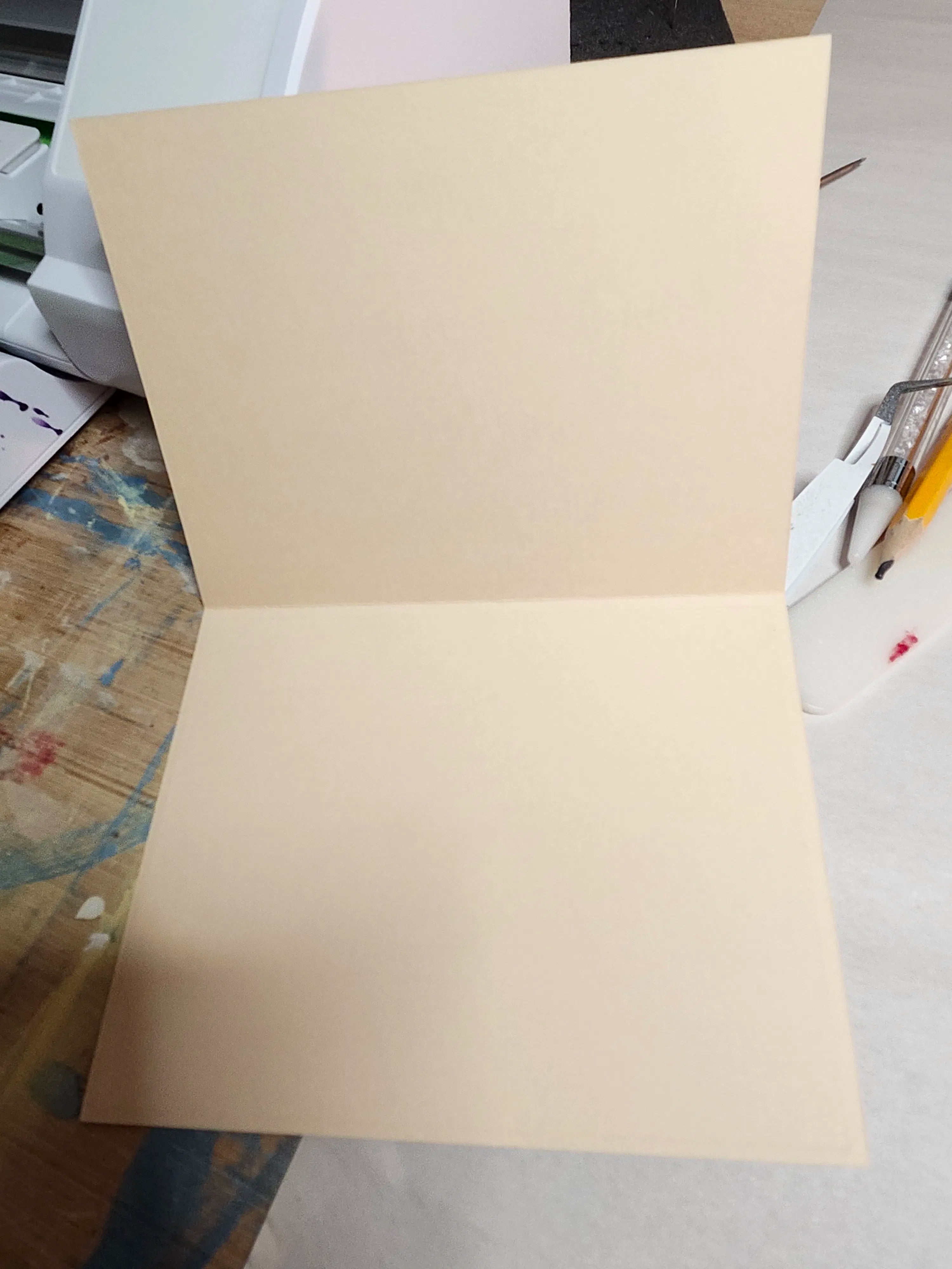 Beige paper on a desk with office supplies in the background