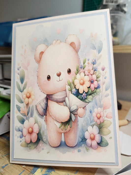 Card with a cute bear holding flowers on a floral background