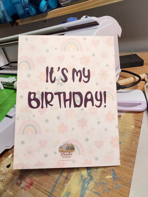 Card with 'It's my birthday!' text on a desk with office supplies.