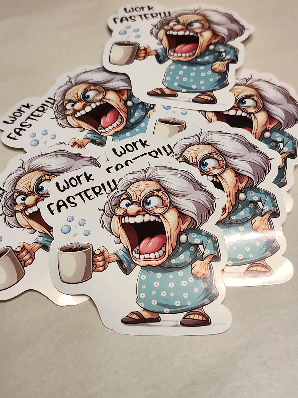 Cartoon sticker of an angry old woman with text 'Work Faster!!' on a beige background