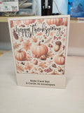 Note card set with 'Happy Thanksgiving' design featuring pumpkins and fall elements on a white surface.