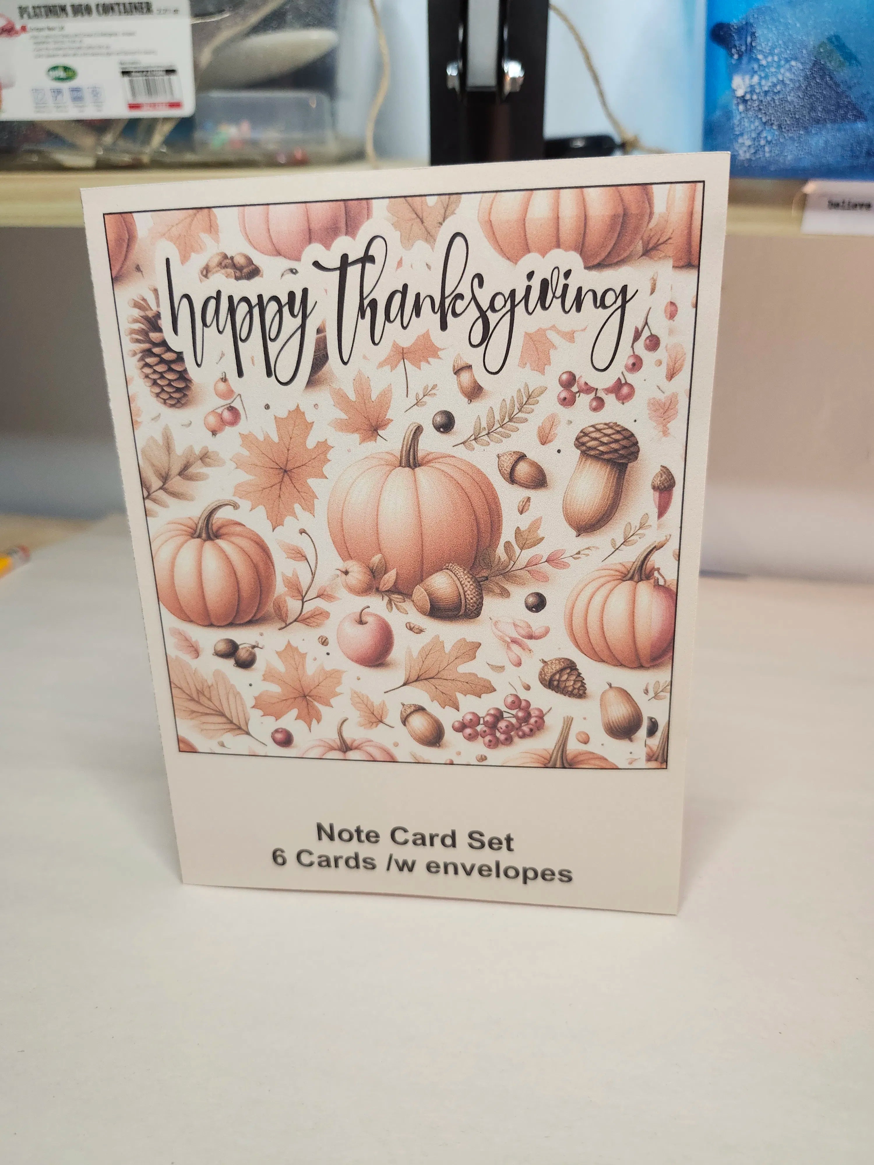 Note card set with 'Happy Thanksgiving' design featuring pumpkins and fall elements on a white surface.