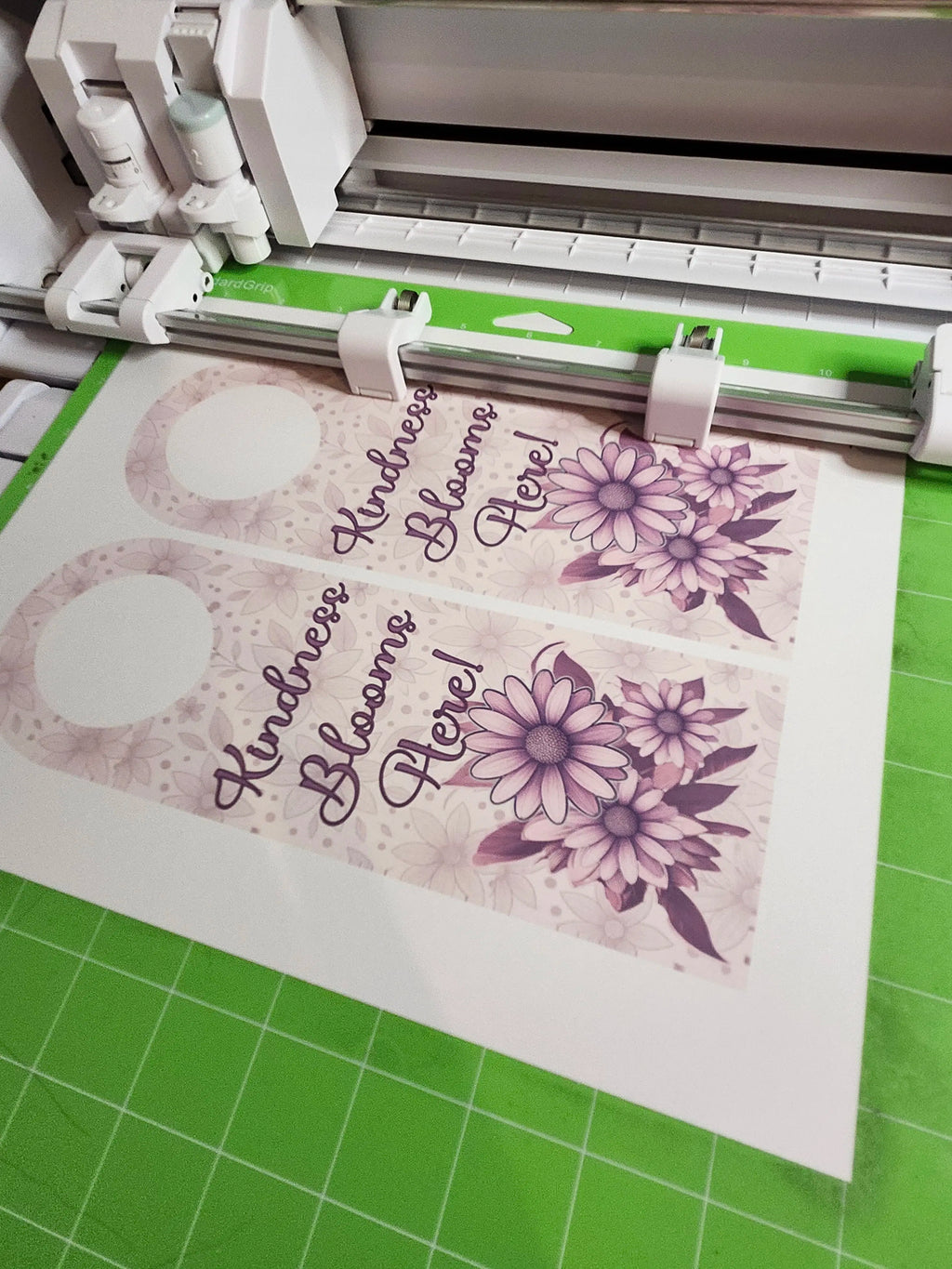 machine with a printed design on paper, featuring flowers and text.