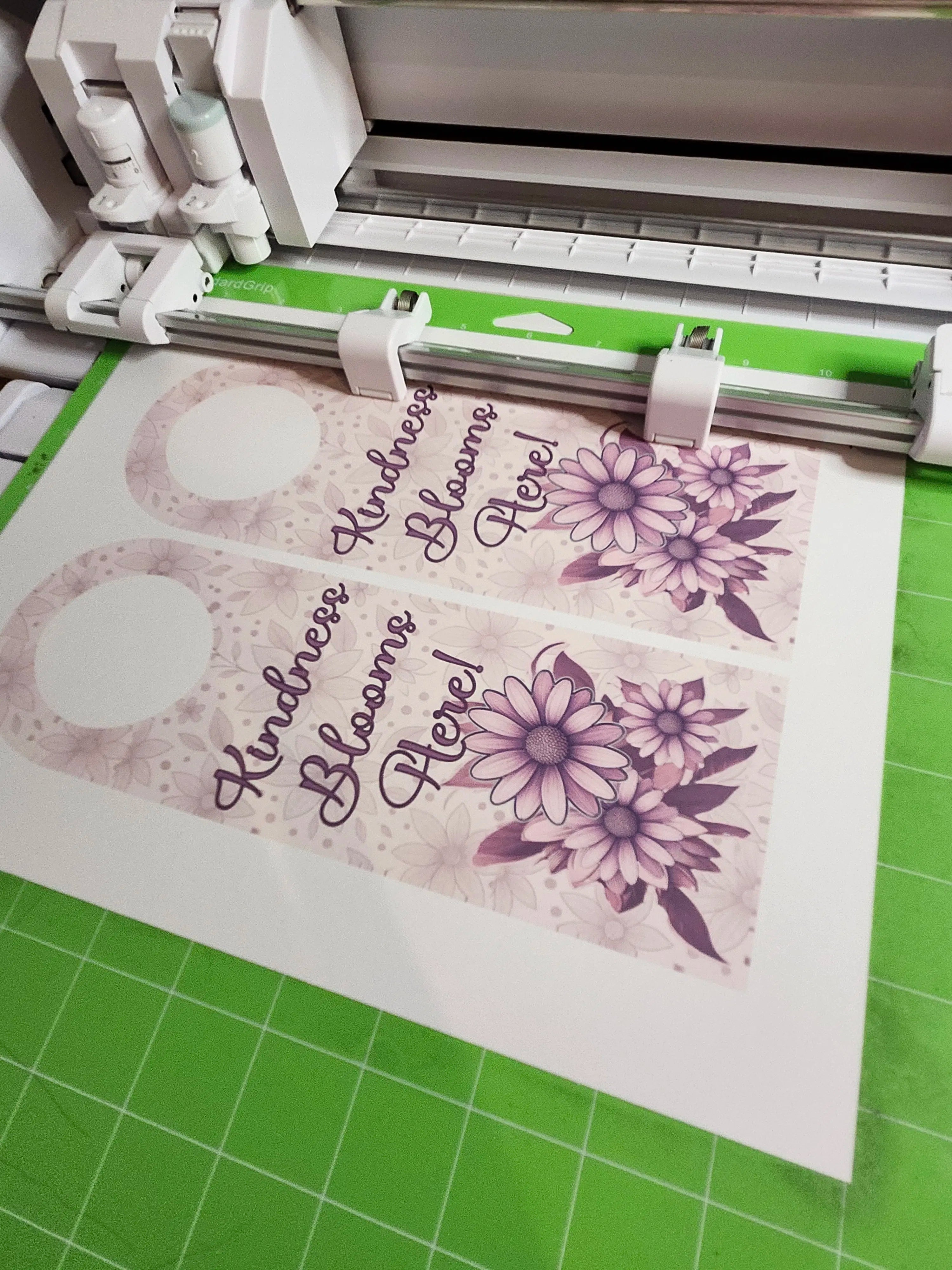 machine with a printed design on paper, featuring flowers and text.