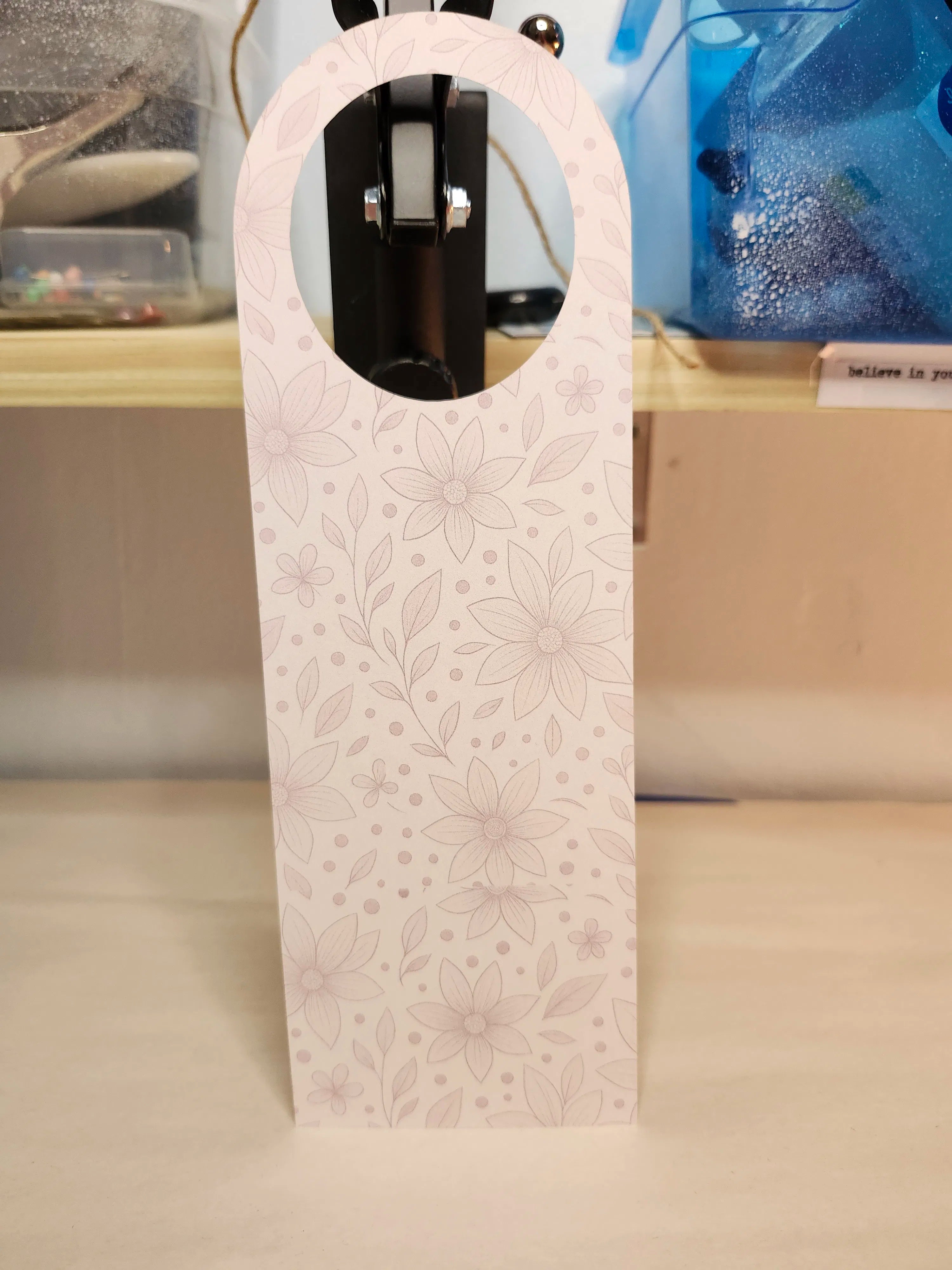 White wine bottle holder with floral pattern on a blurred background