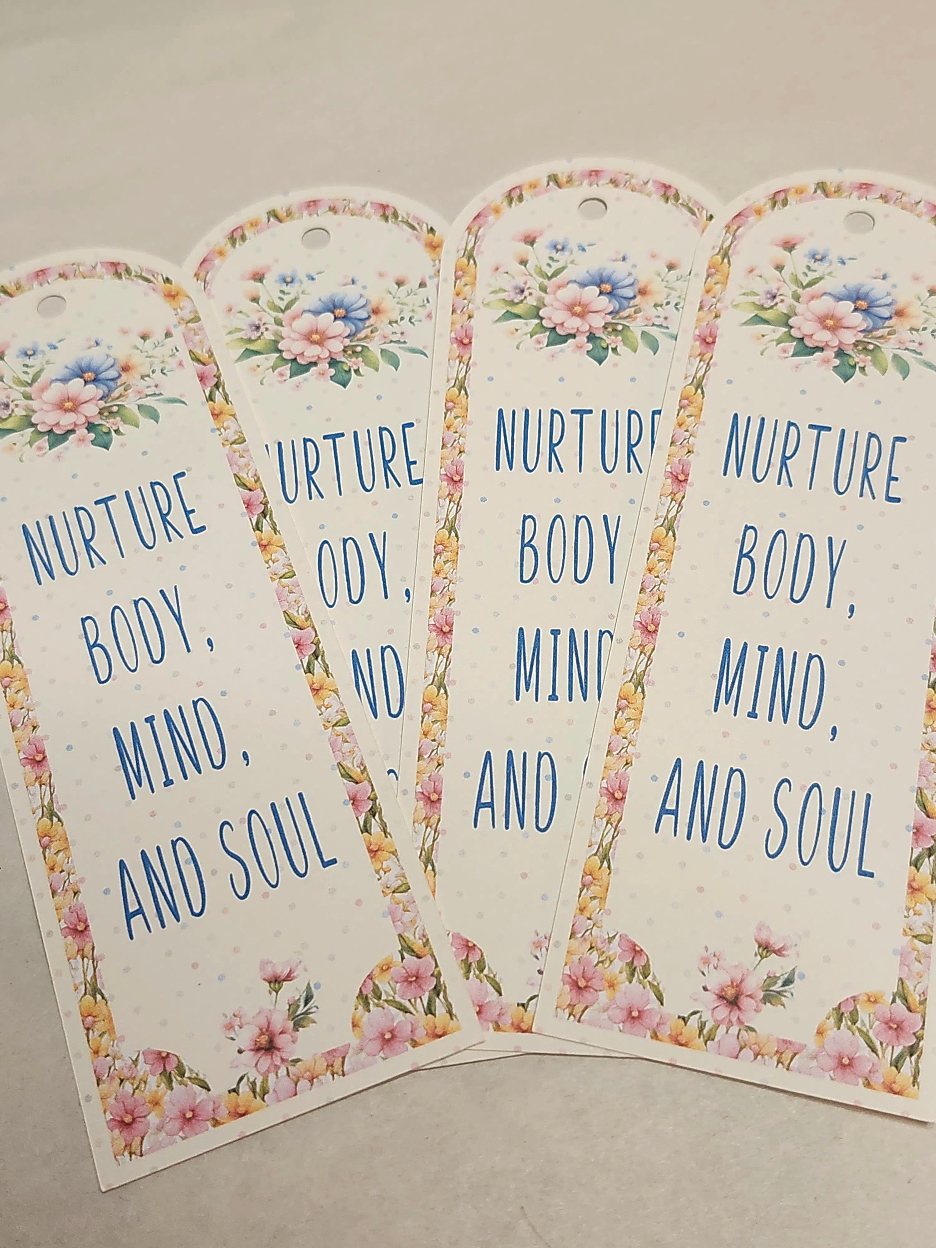 Four floral-themed tags with text on a neutral background