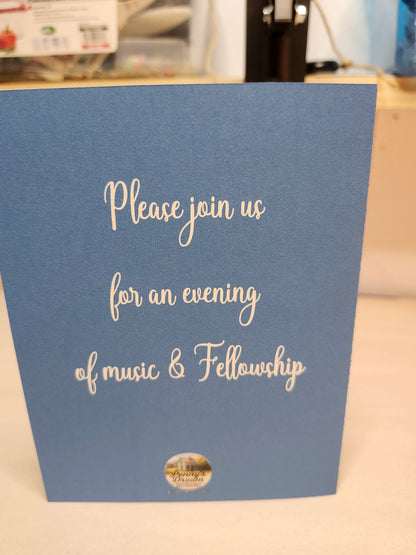Blue card with white text inviting to an evening of music and fellowship, on a blurred indoor background.