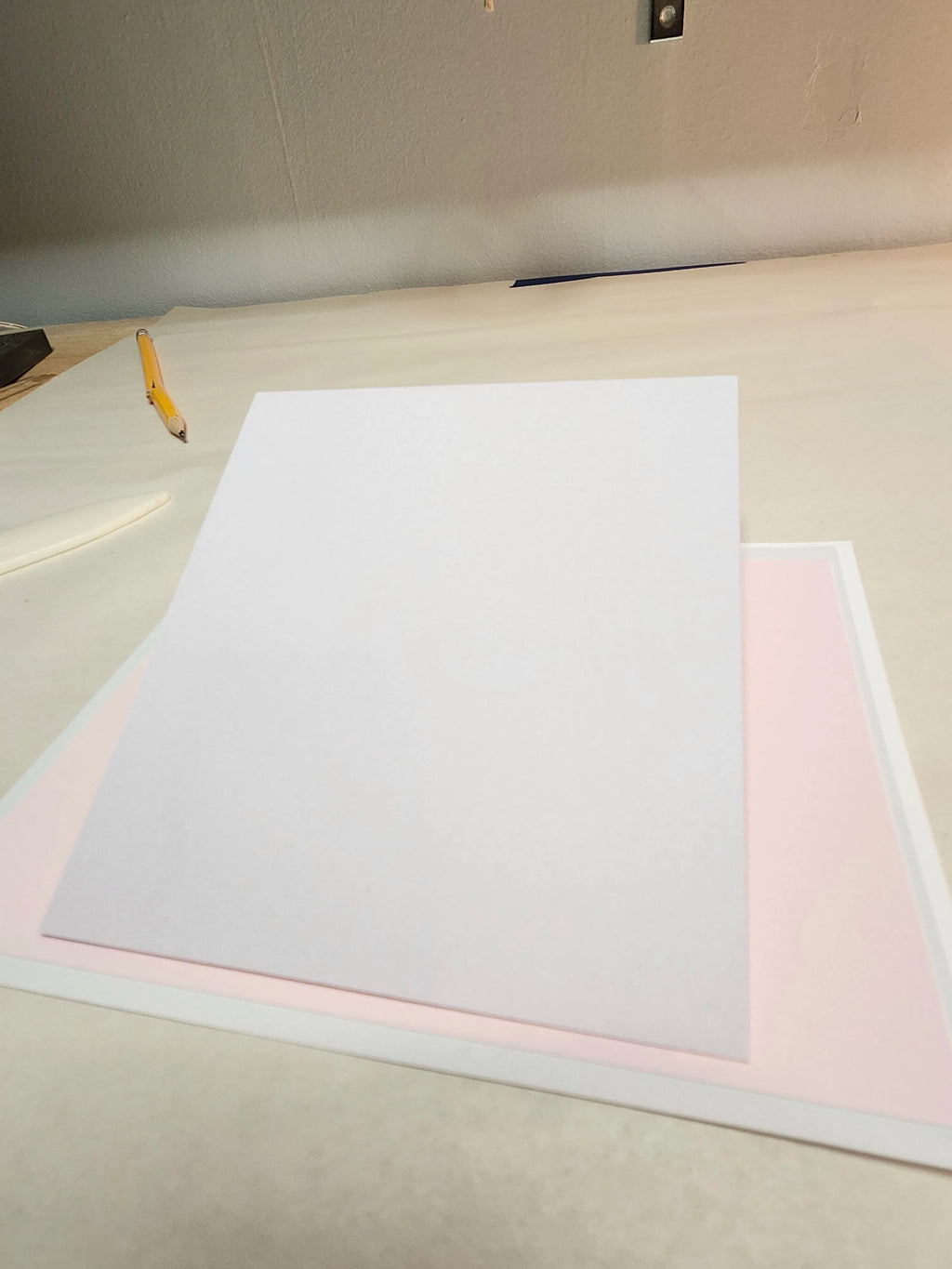 White paper on a light-colored surface with a pencil to the left.