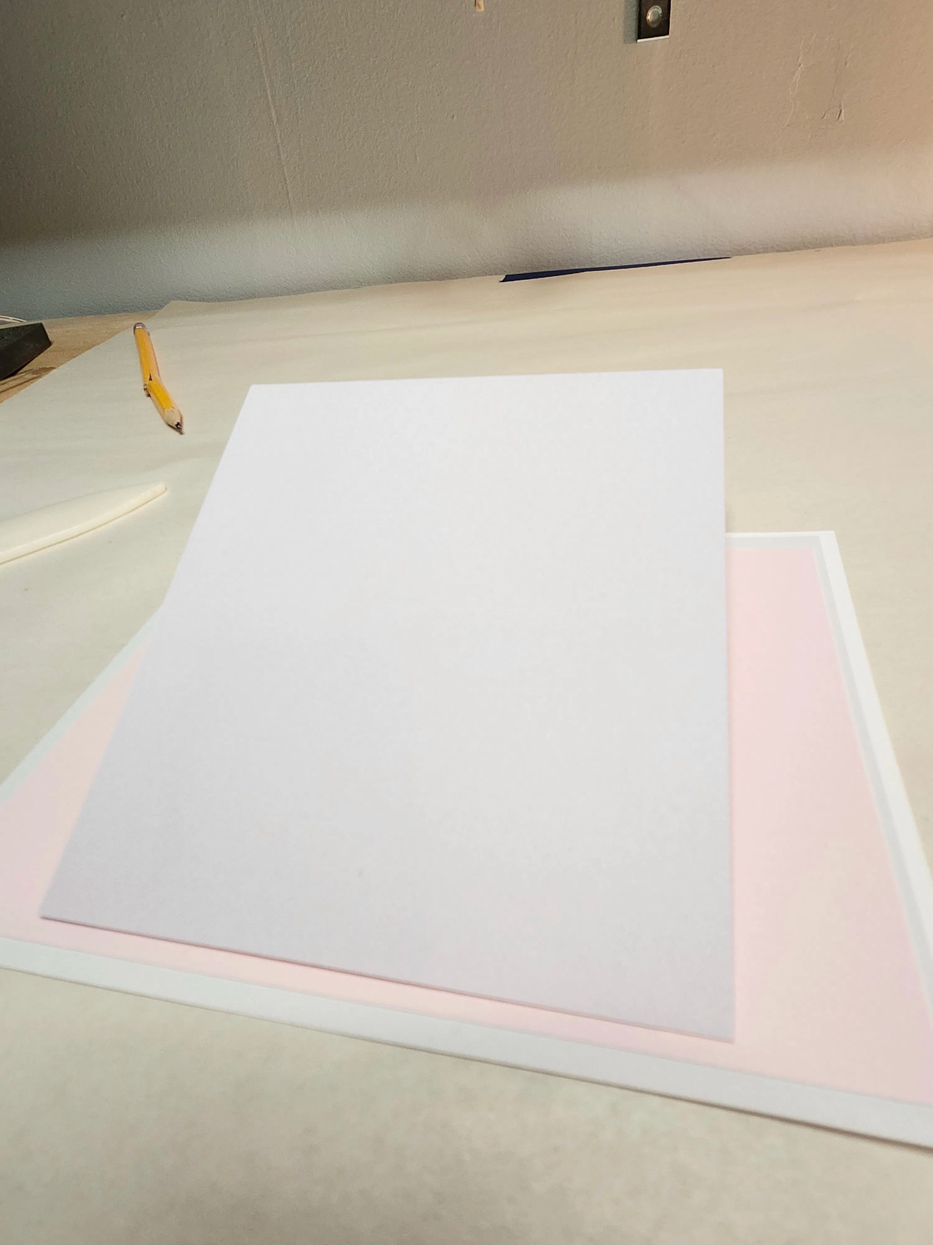 White paper on a light-colored surface with a pencil to the left.