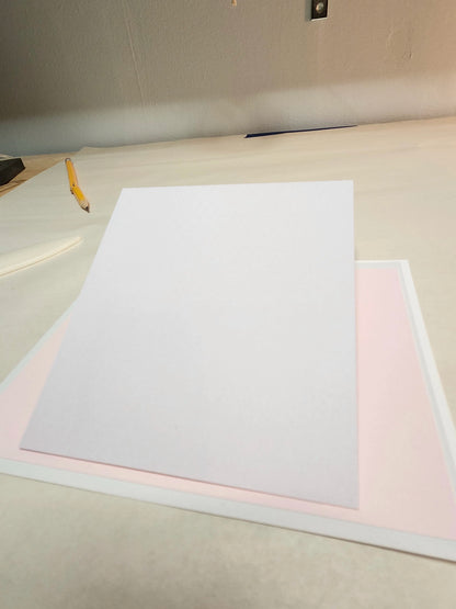White paper on a light-colored surface with a pencil to the left.