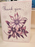 Greeting card with floral design and 'Thank you' text on a light background