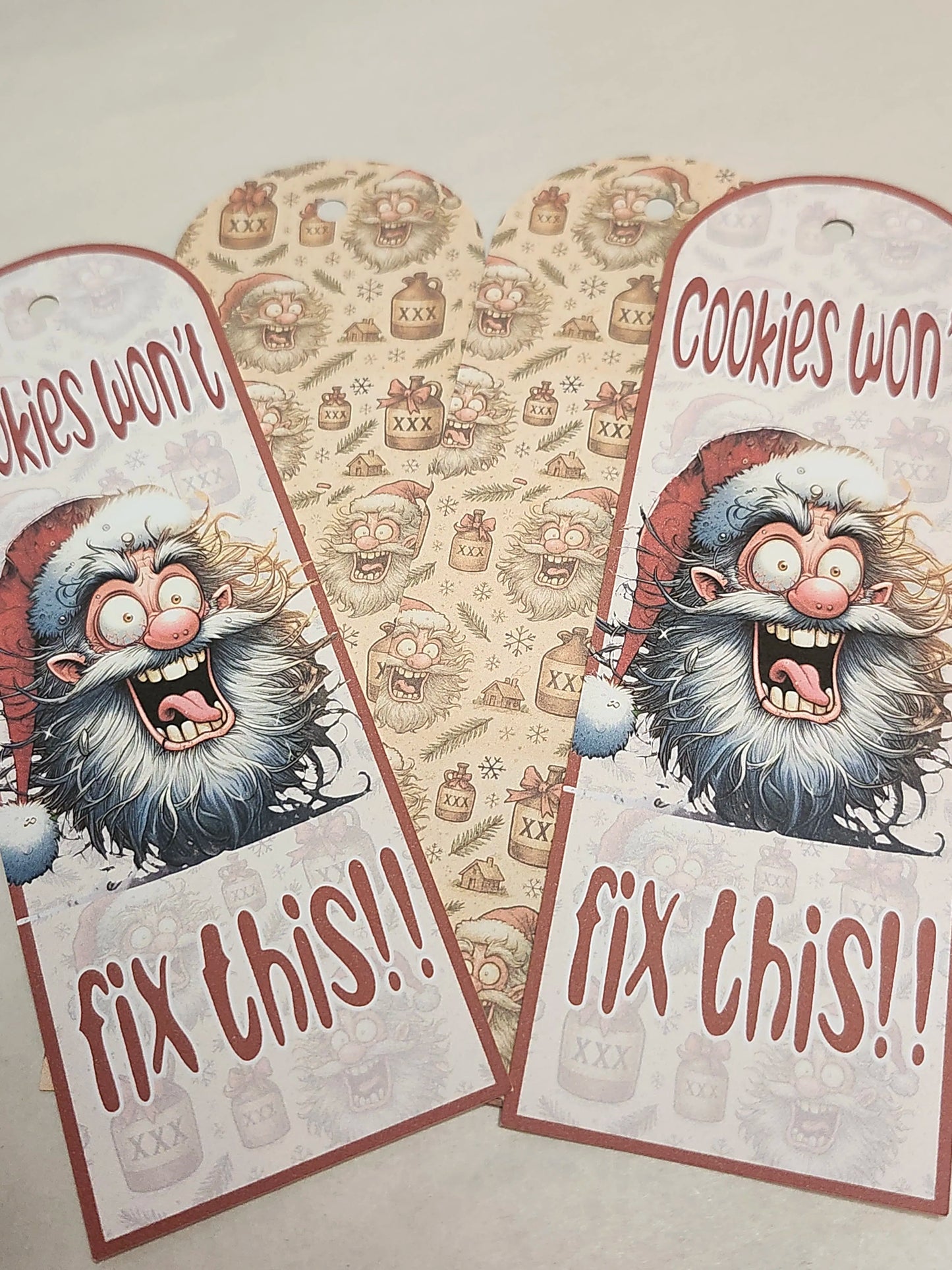 Two festive gift tags with a cartoon Santa Claus and text 'Cookies won't fix this!!' on a patterned background.