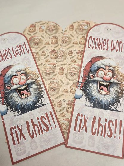 Two festive gift tags with a cartoon Santa Claus and text 'Cookies won't fix this!!' on a patterned background.