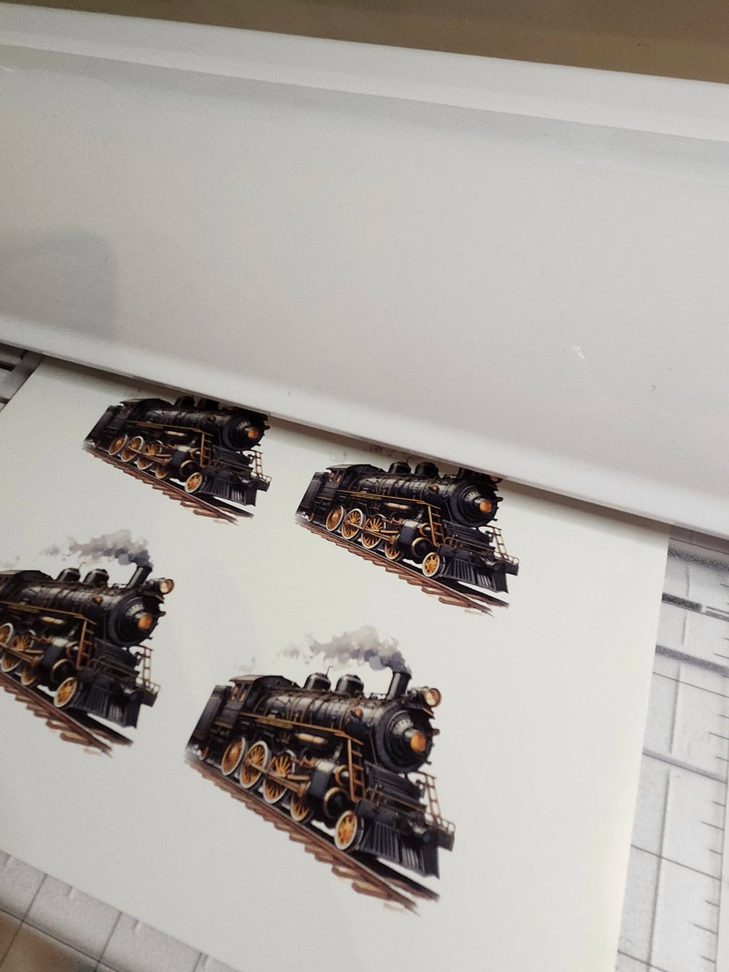 Printed steam locomotive design on a white surface with a grid pattern.