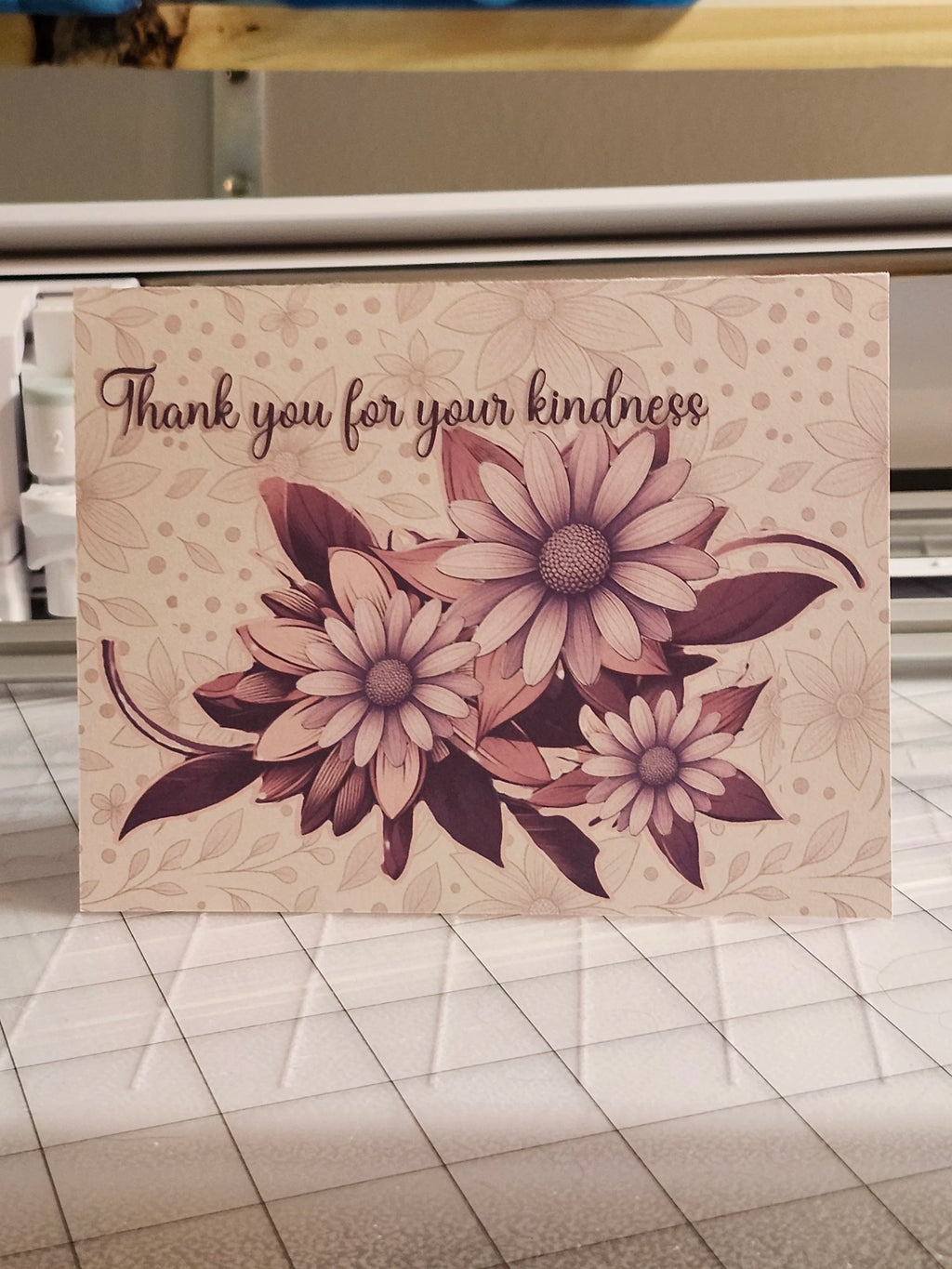 Floral card with 'Thank you for your kindness' text on a tiled floor background