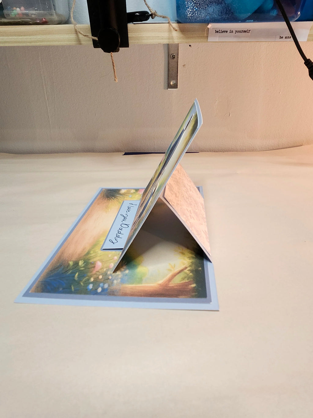 Open greeting card on a beige surface with blurred background