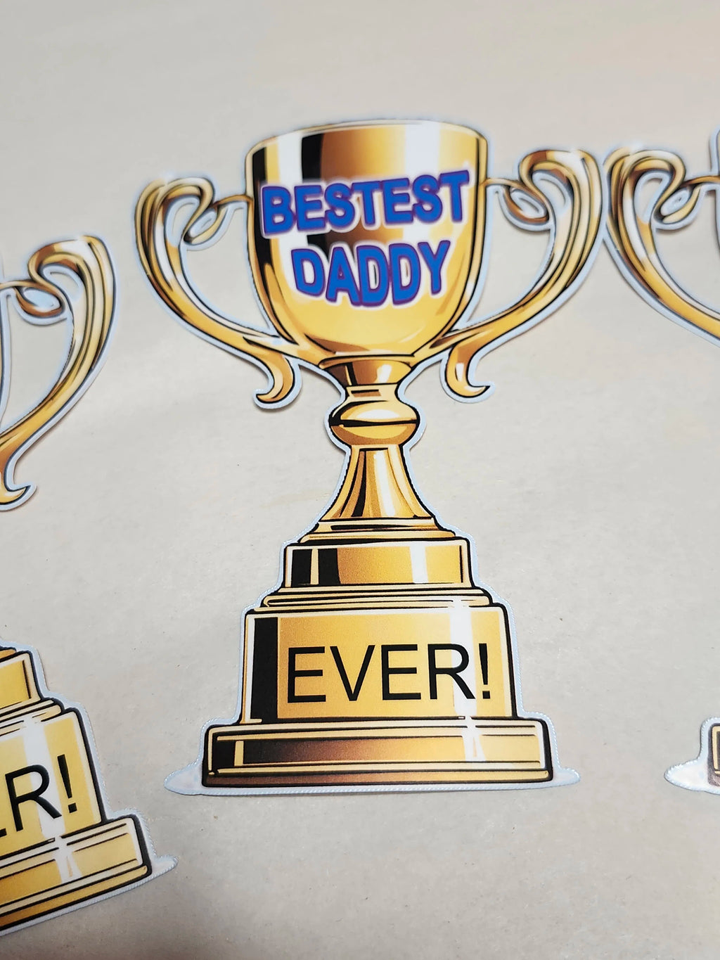 Gold trophy with 'Bestest Daddy Ever!' text on a beige background