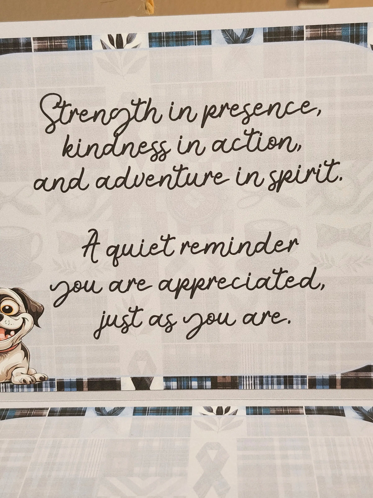 Text on a fabric background with a cartoon dog character, featuring motivational quote.