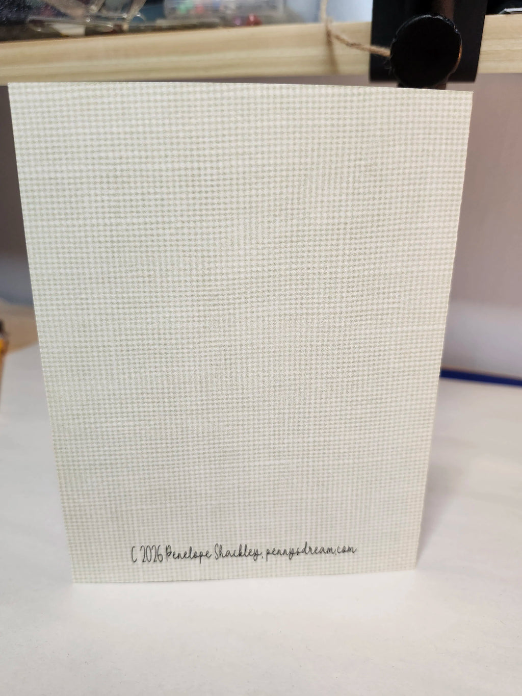 Beige textured gift bag with a visible brand name on a white surface
