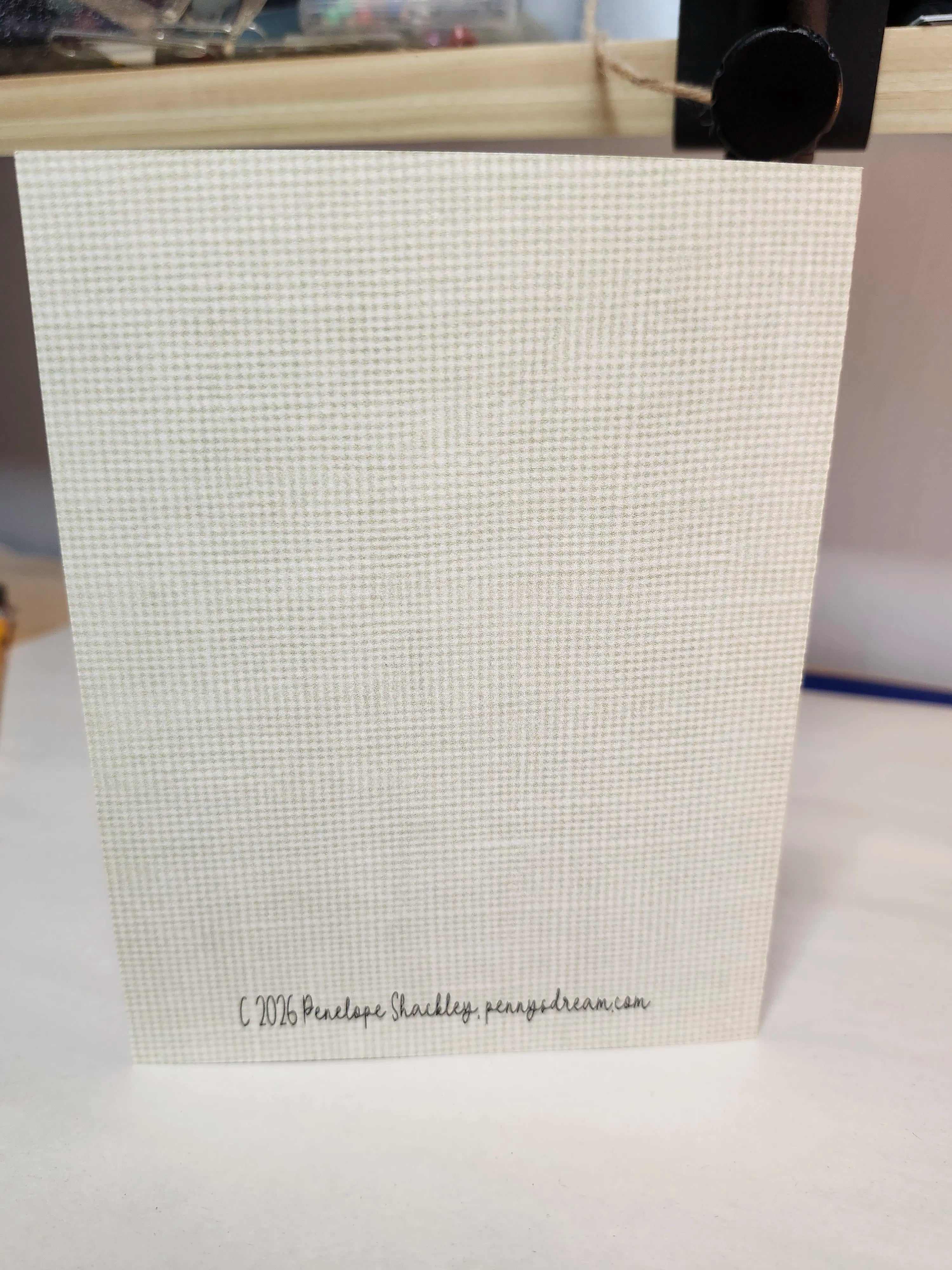 Beige textured gift bag with a visible brand name on a white surface