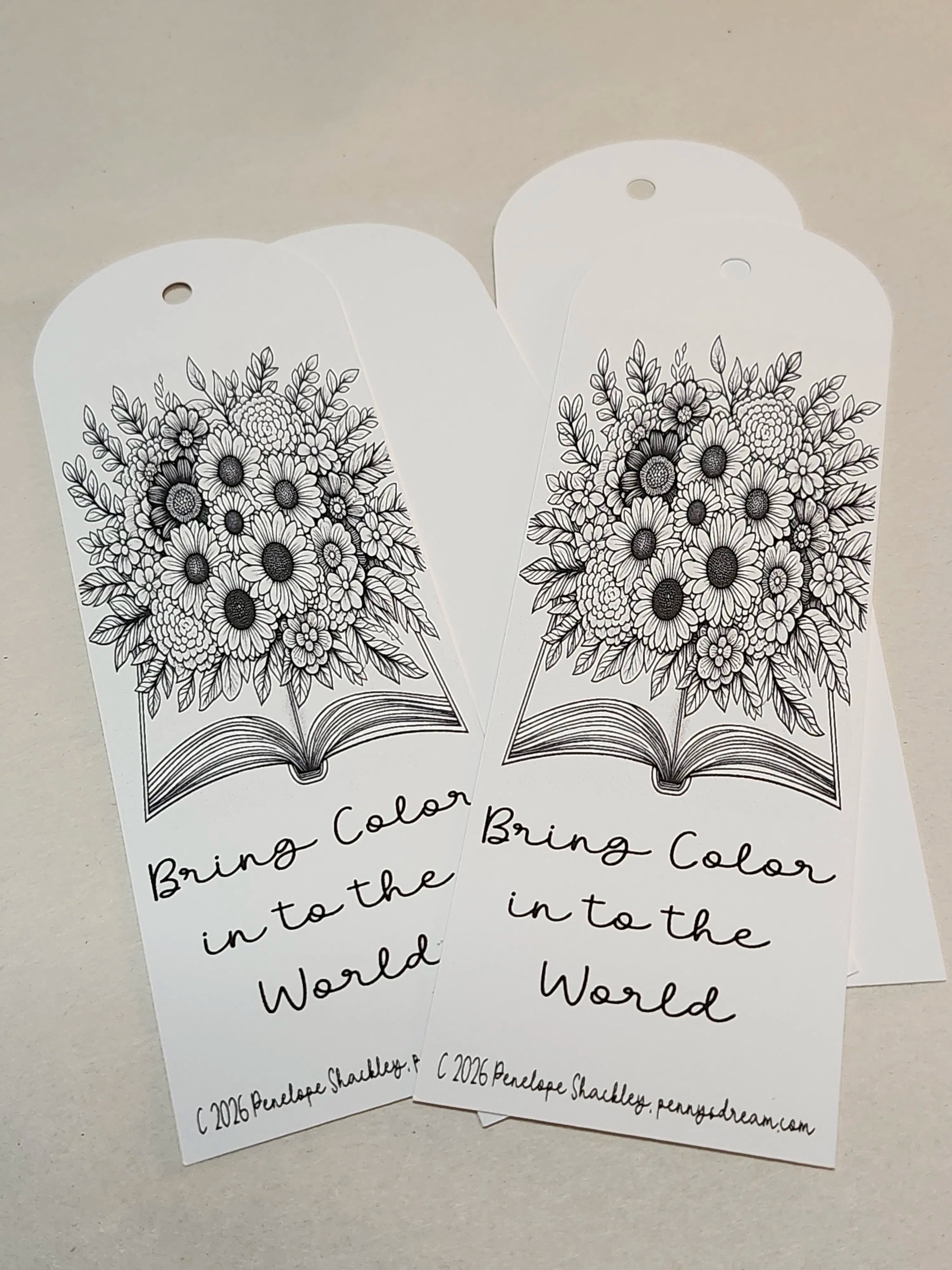 Two white tags with black floral designs and text on a beige background