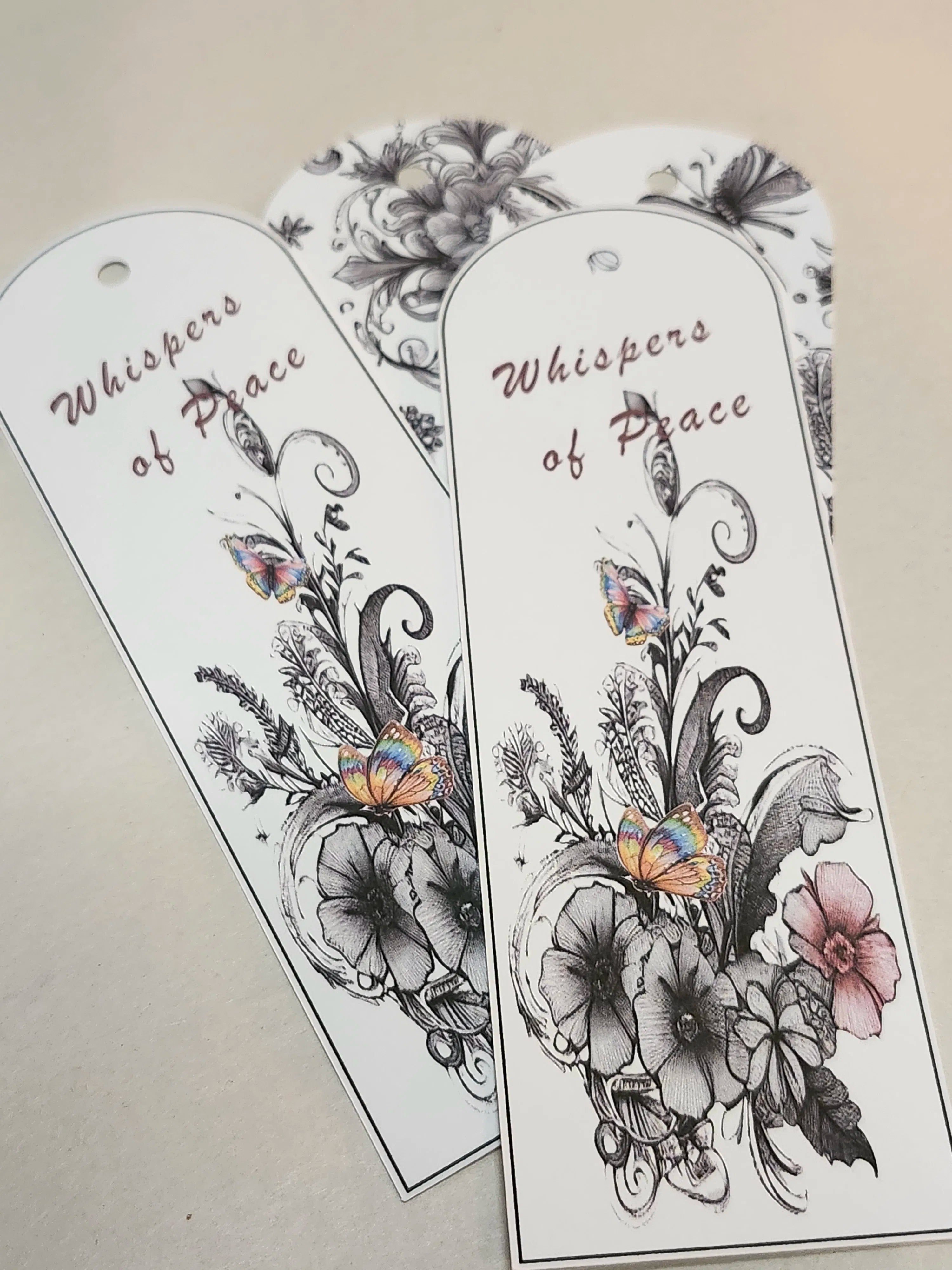 Floral bookmarks with 'Whispers of Peace' text on a neutral background