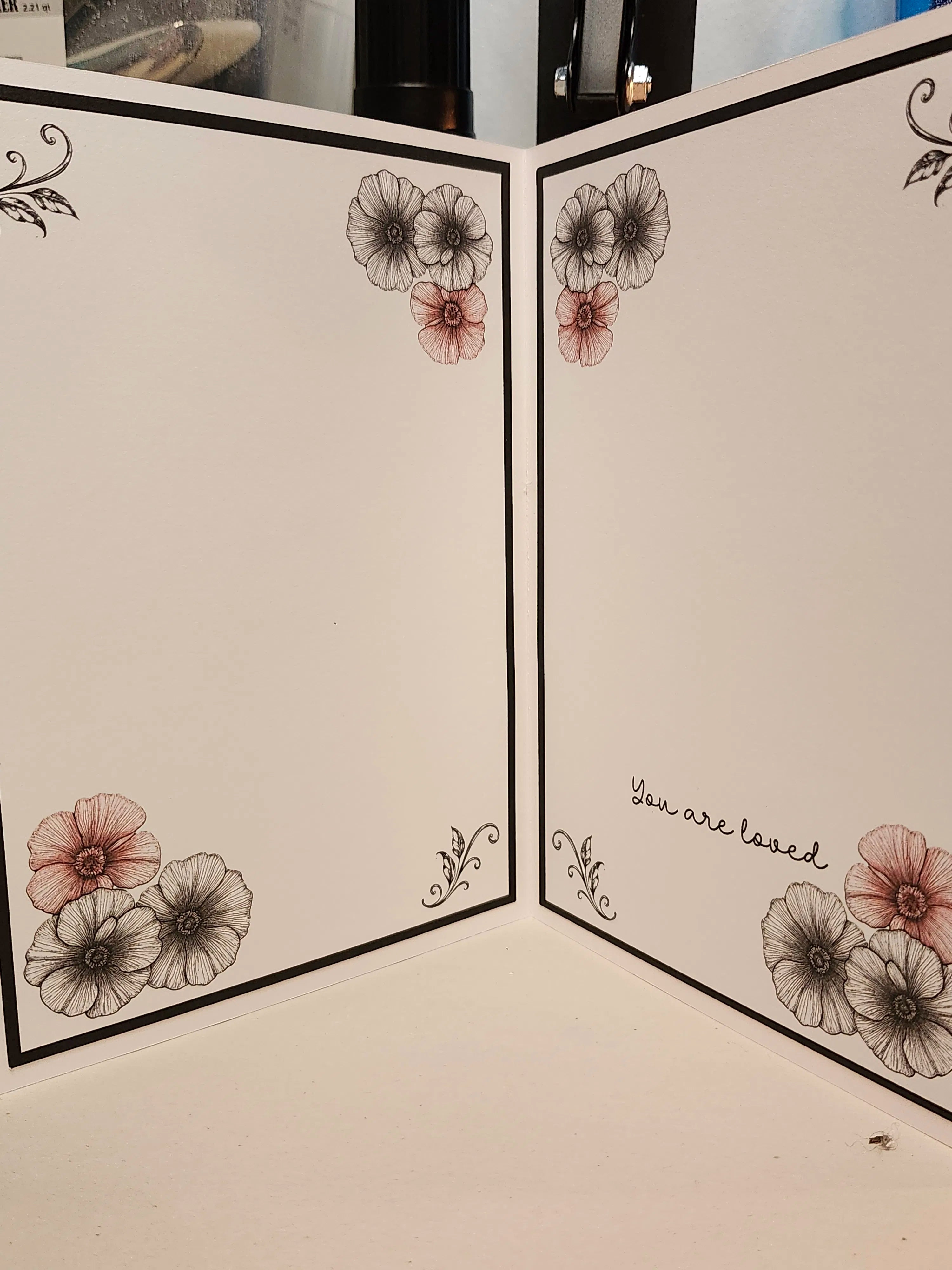 Floral design on a folded card with 'You are loved' text.