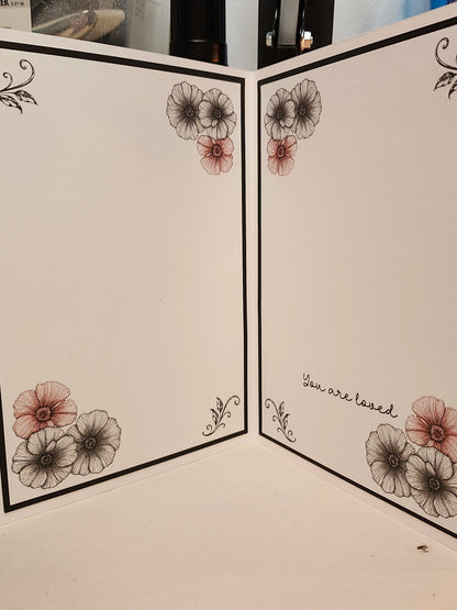 Floral design on a folded card with 'You are loved' text.