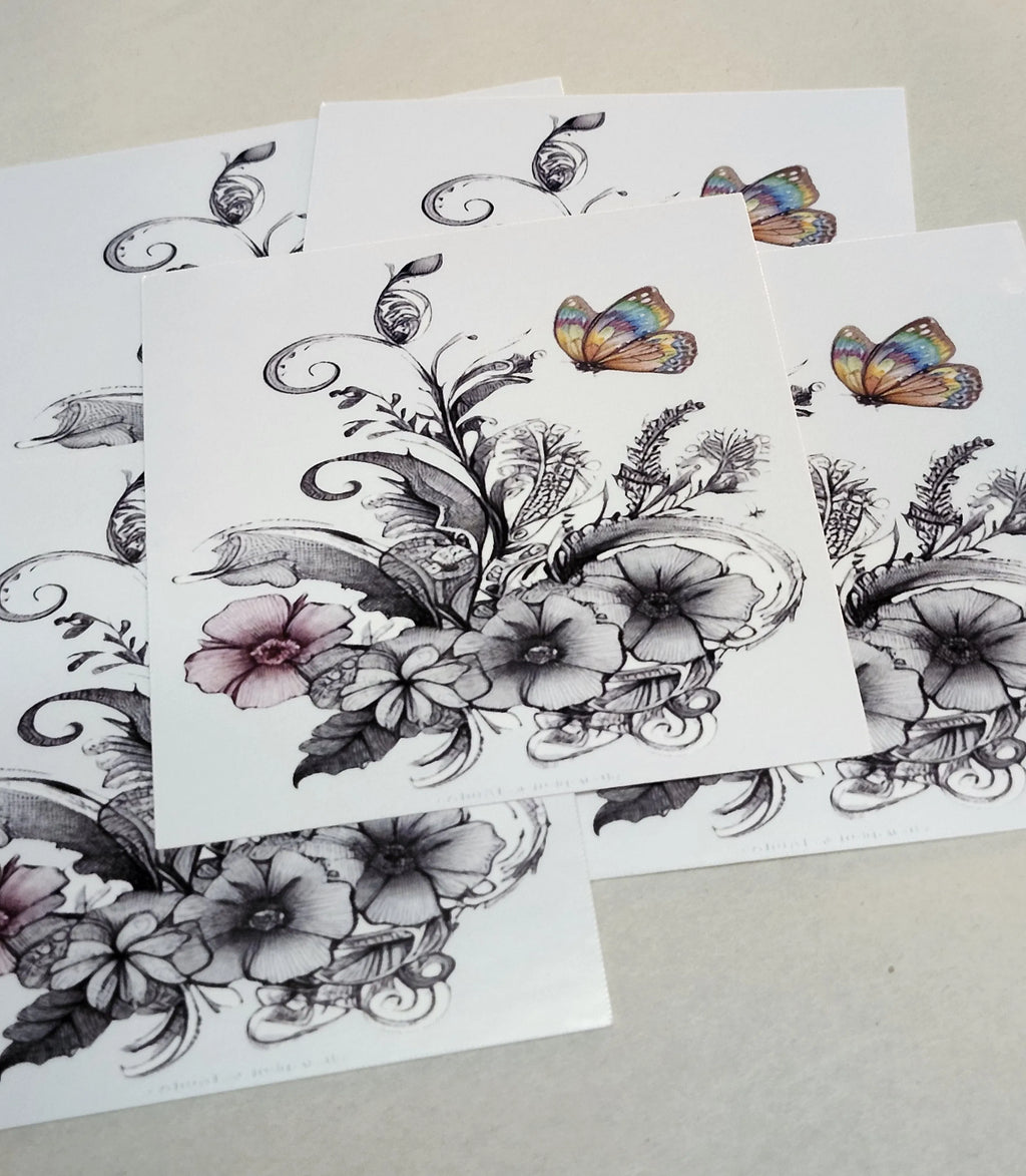 Floral and butterfly temporary tattoos on white paper with a beige background