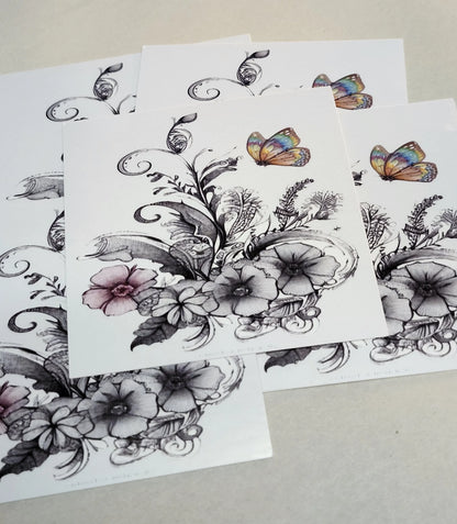 Floral and butterfly temporary tattoos on white paper with a beige background