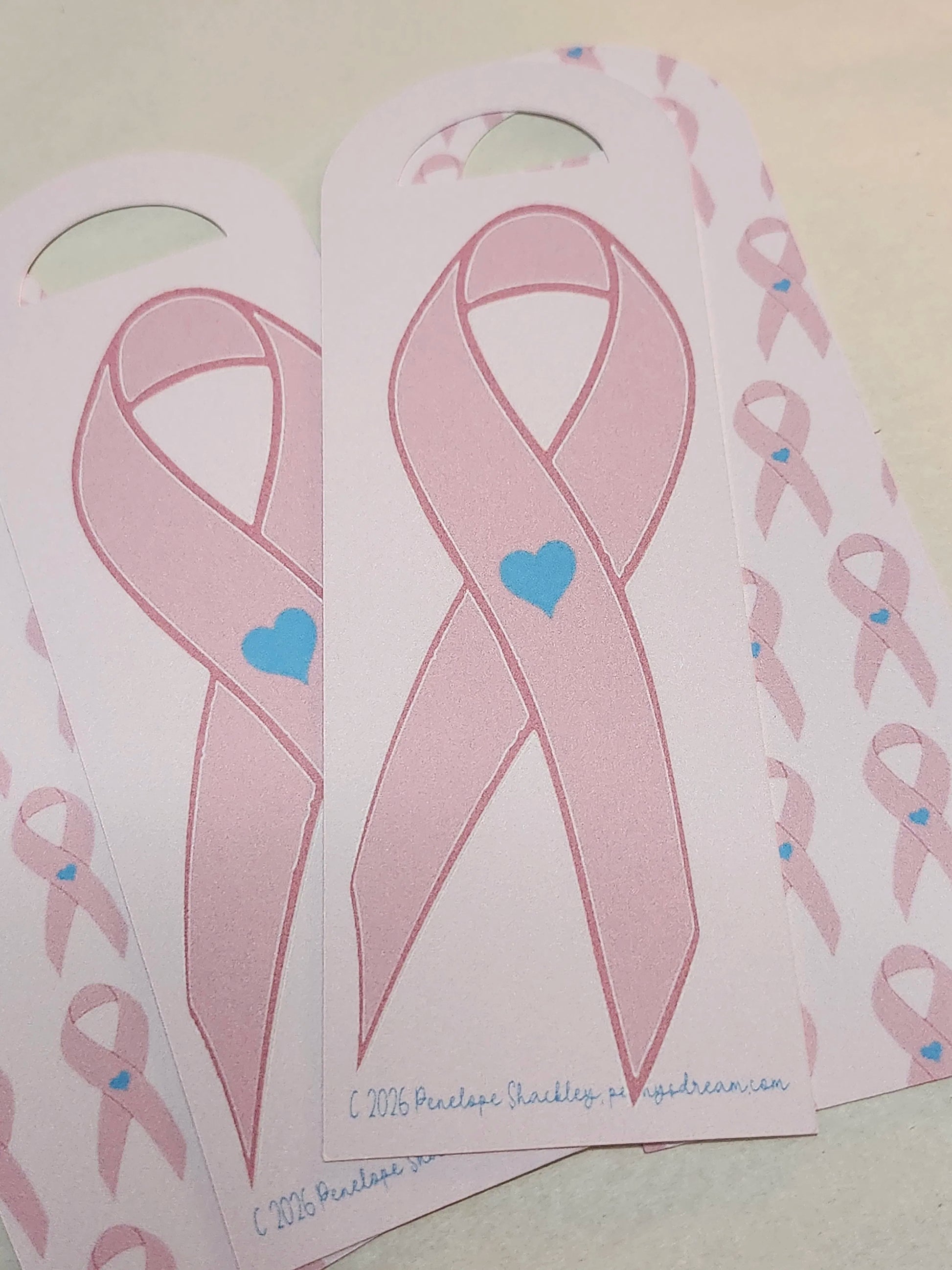 Pink ribbons with blue hearts on a white background