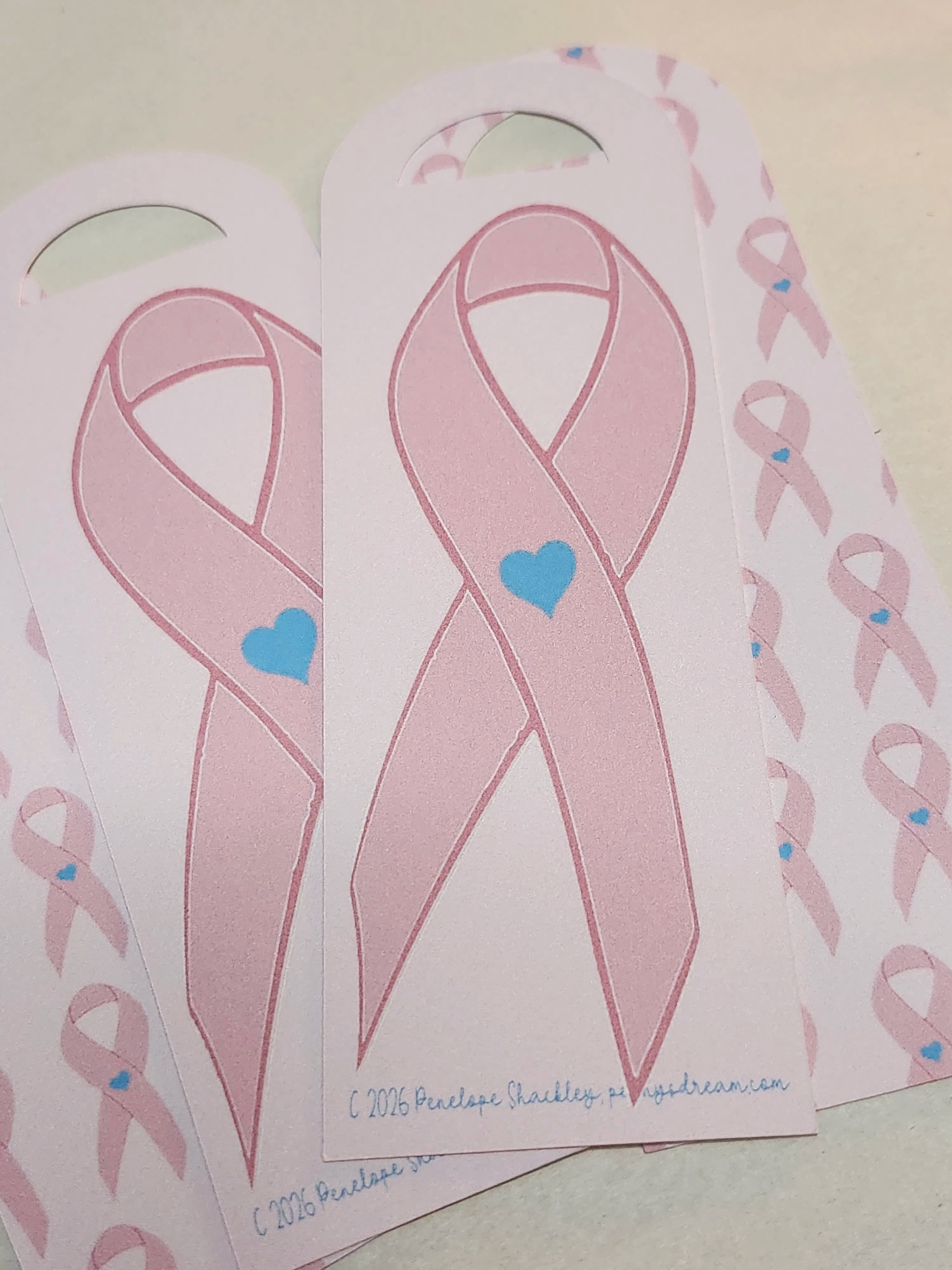 Pink ribbons with blue hearts on a white background