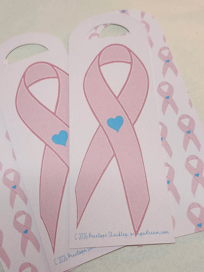 Pink ribbons with blue hearts on a white background