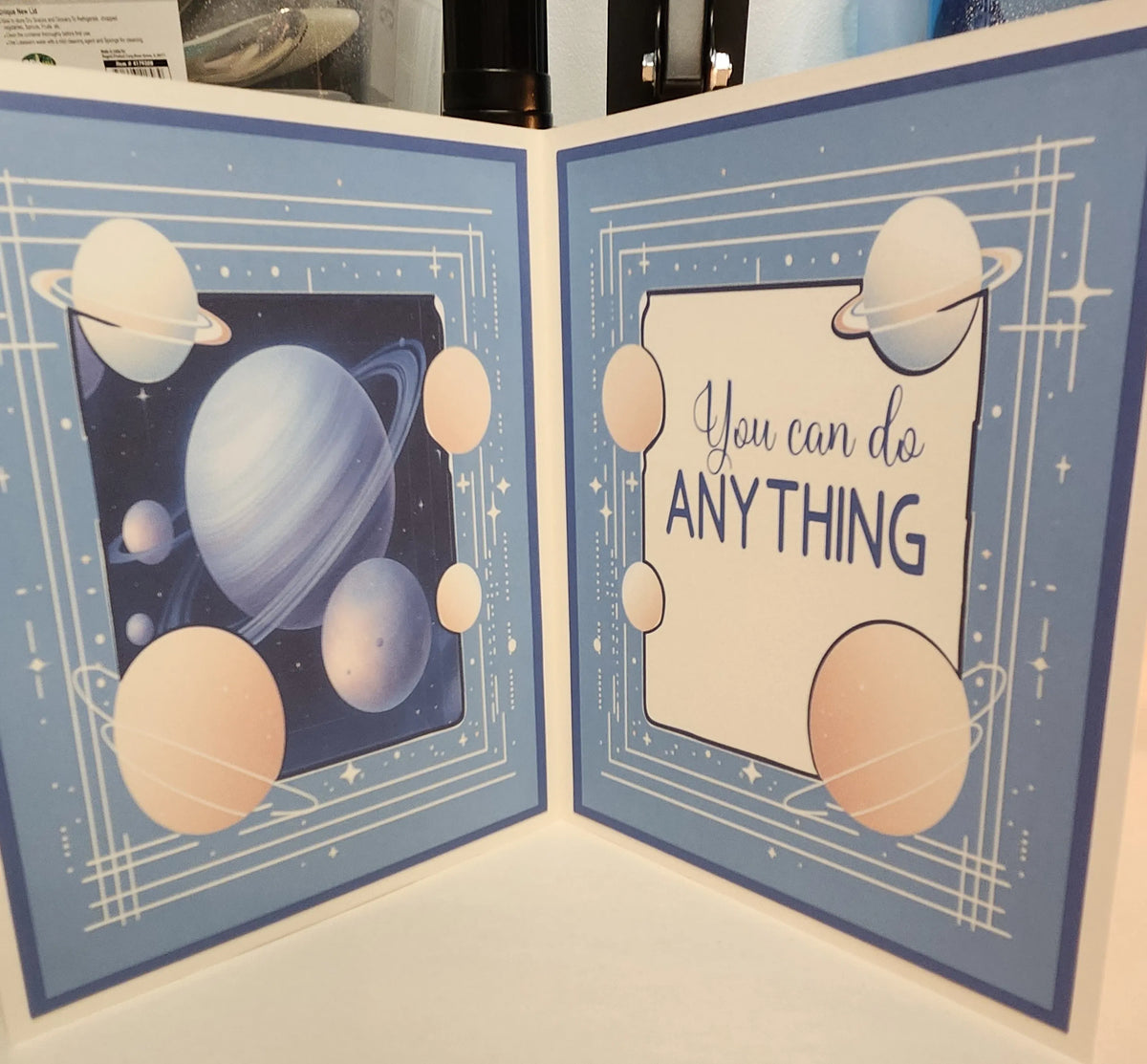 Card with space-themed design and motivational quote on a blue background