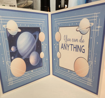Card with space-themed design and motivational quote on a blue background