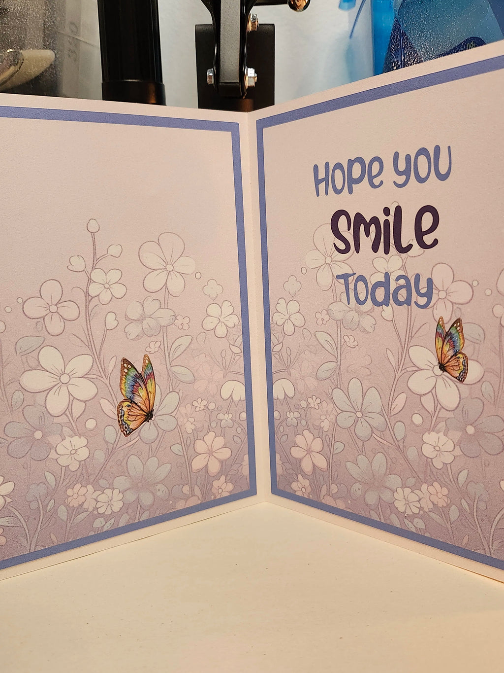 Greeting card with floral design and butterfly illustration, featuring the text 'Hope you smile today'.