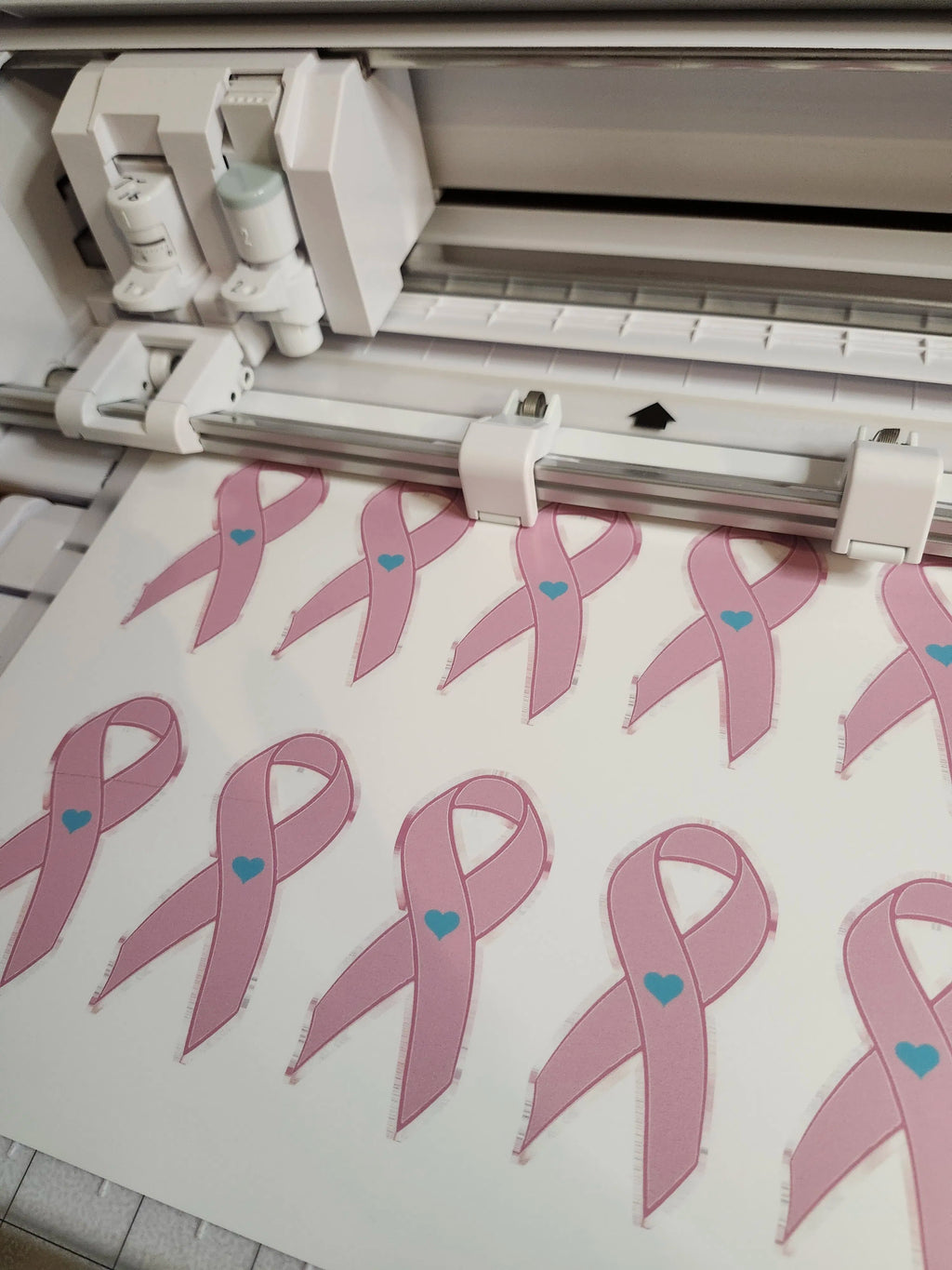 machine with pink ribbons and blue hearts on a cutting mat
