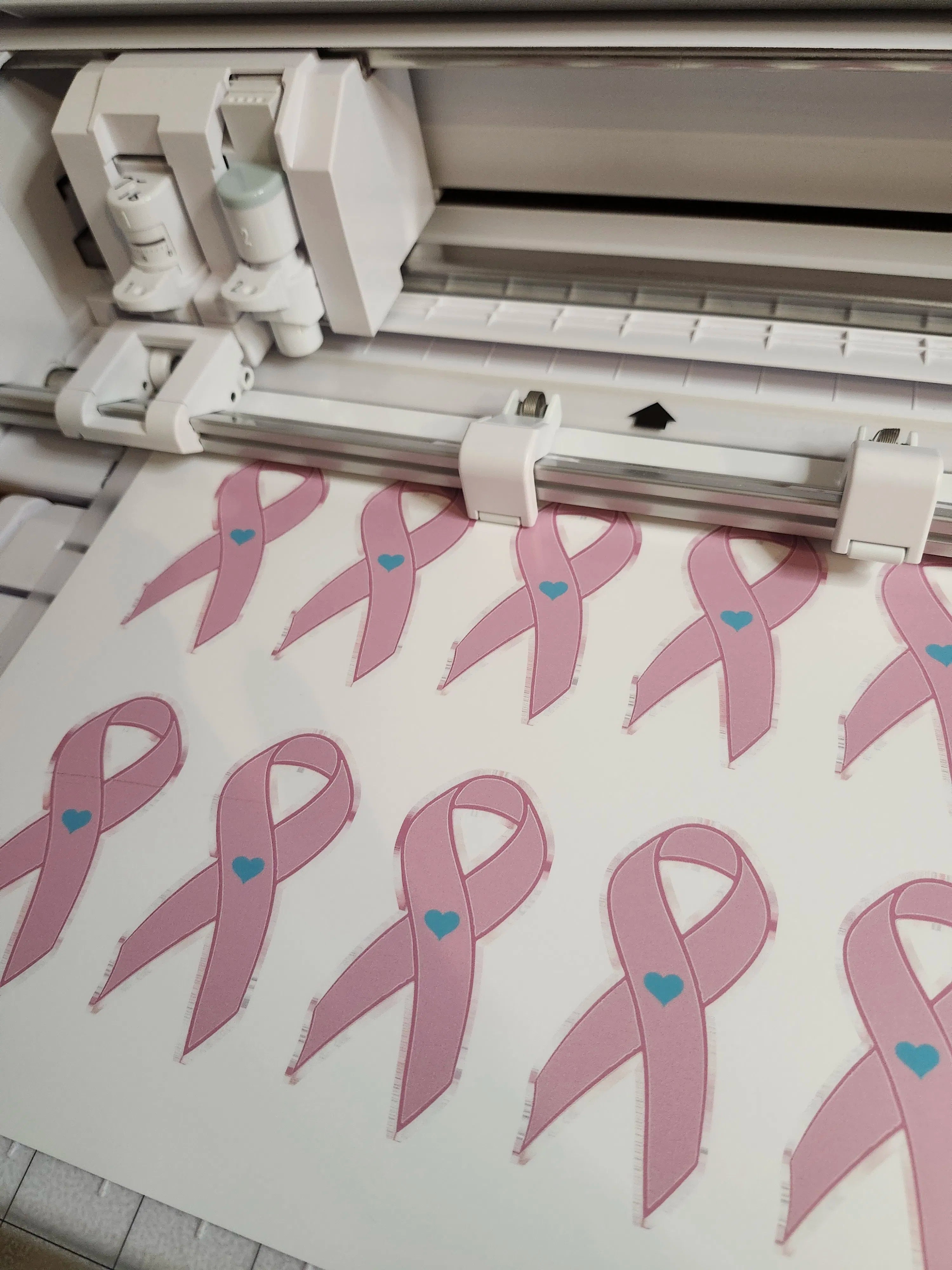 machine with pink ribbons and blue hearts on a cutting mat
