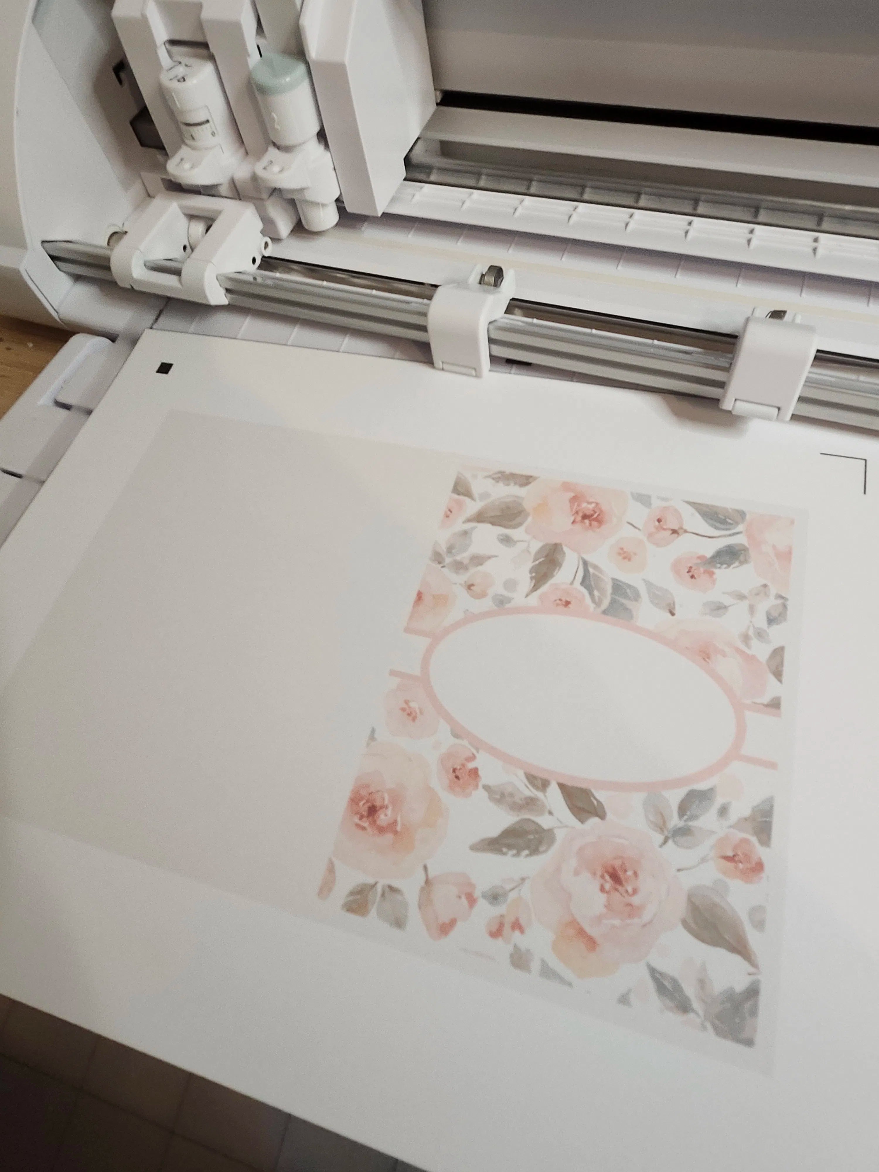Floral design being printed on a white surface with a printer in the background.