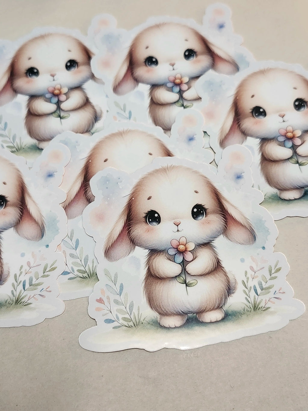 Stickers of cute cartoon bunnies with flowers on a beige background