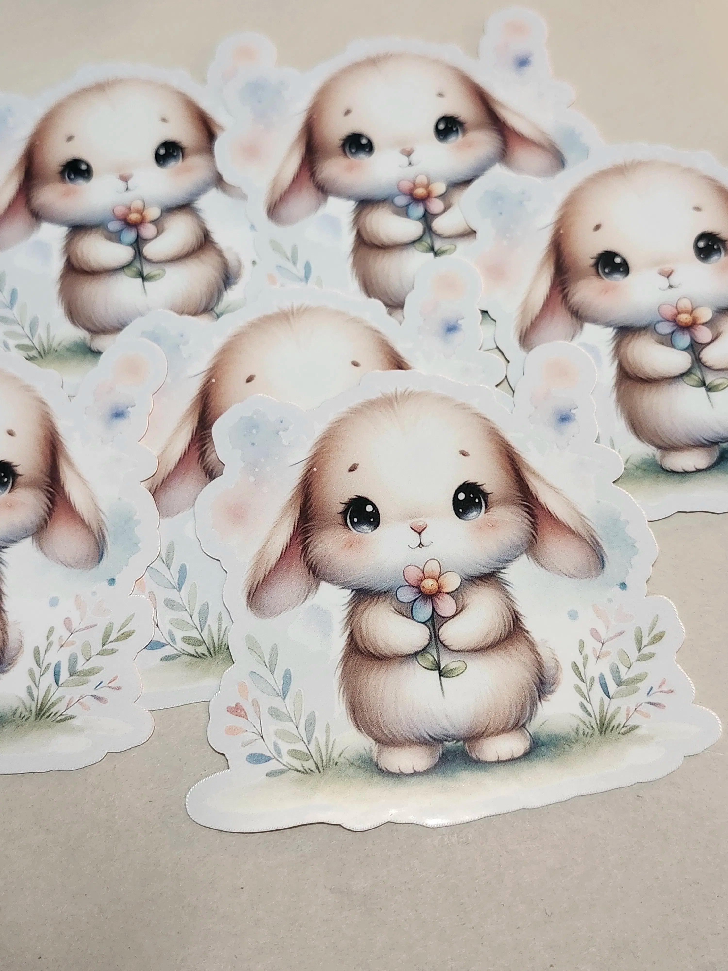 Stickers of cute cartoon bunnies with flowers on a beige background